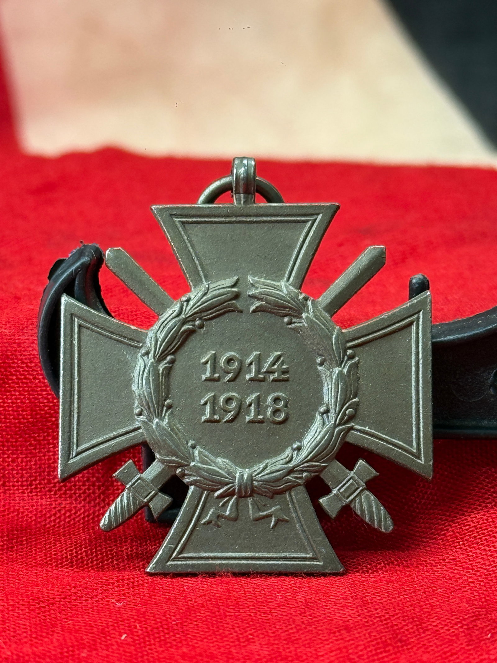 WWI German 1914–1918 Veterans Commemorative Cross Pendant: This World War I German commemorative pendant is designed as a Maltese cross with crossed swords behind the arms and a central laurel wreath enclosing the dates 1914–1918. The reverse is stamped "T.