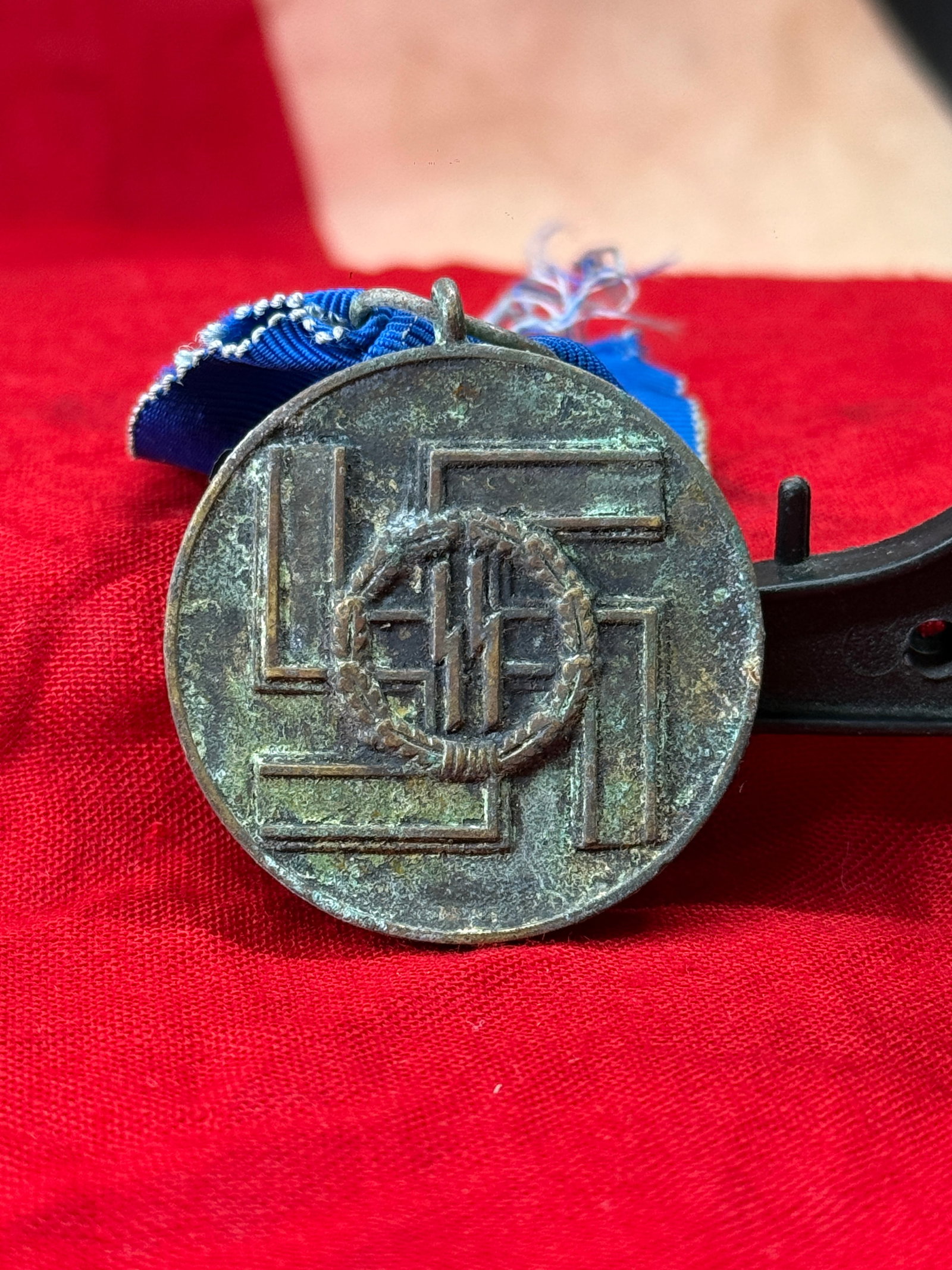 WWII German SS 8-Year Long Service Medal (SS-Dienstauszeichnung): Awarded to members of the Schutzstaffel (SS) in recognition of eight years of faithful service, this circular long service medal features the SS runes enclosed within an oak wreath on the obverse. The