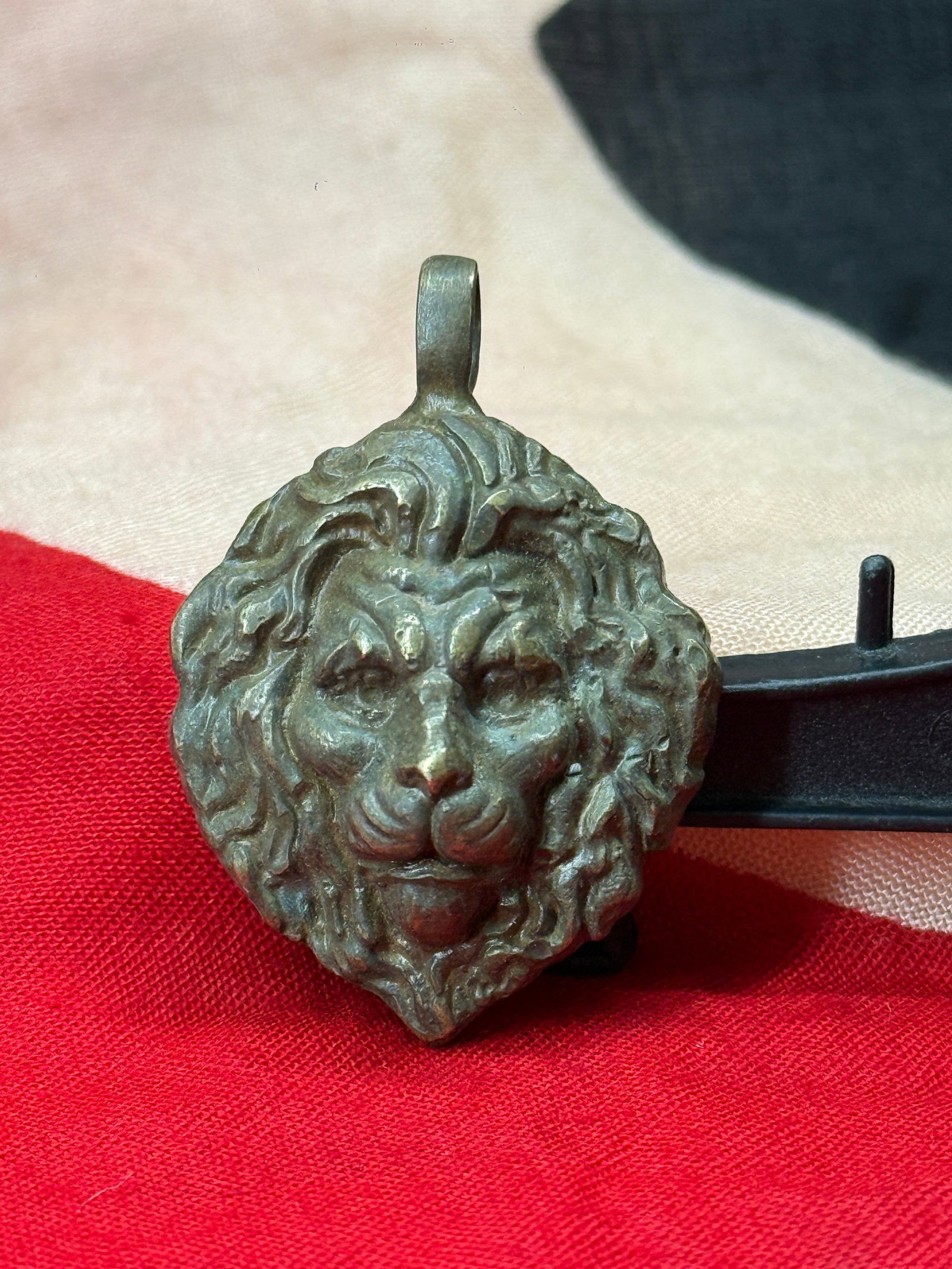 WWII German Waffen-SS Division Officer's Lion Head Pendant: This cast metal pendant depicts a detailed lion's head in high relief with a flowing mane and integral suspension loop at the top for wear as a pendant. The reverse is hollow-backed, a construction co