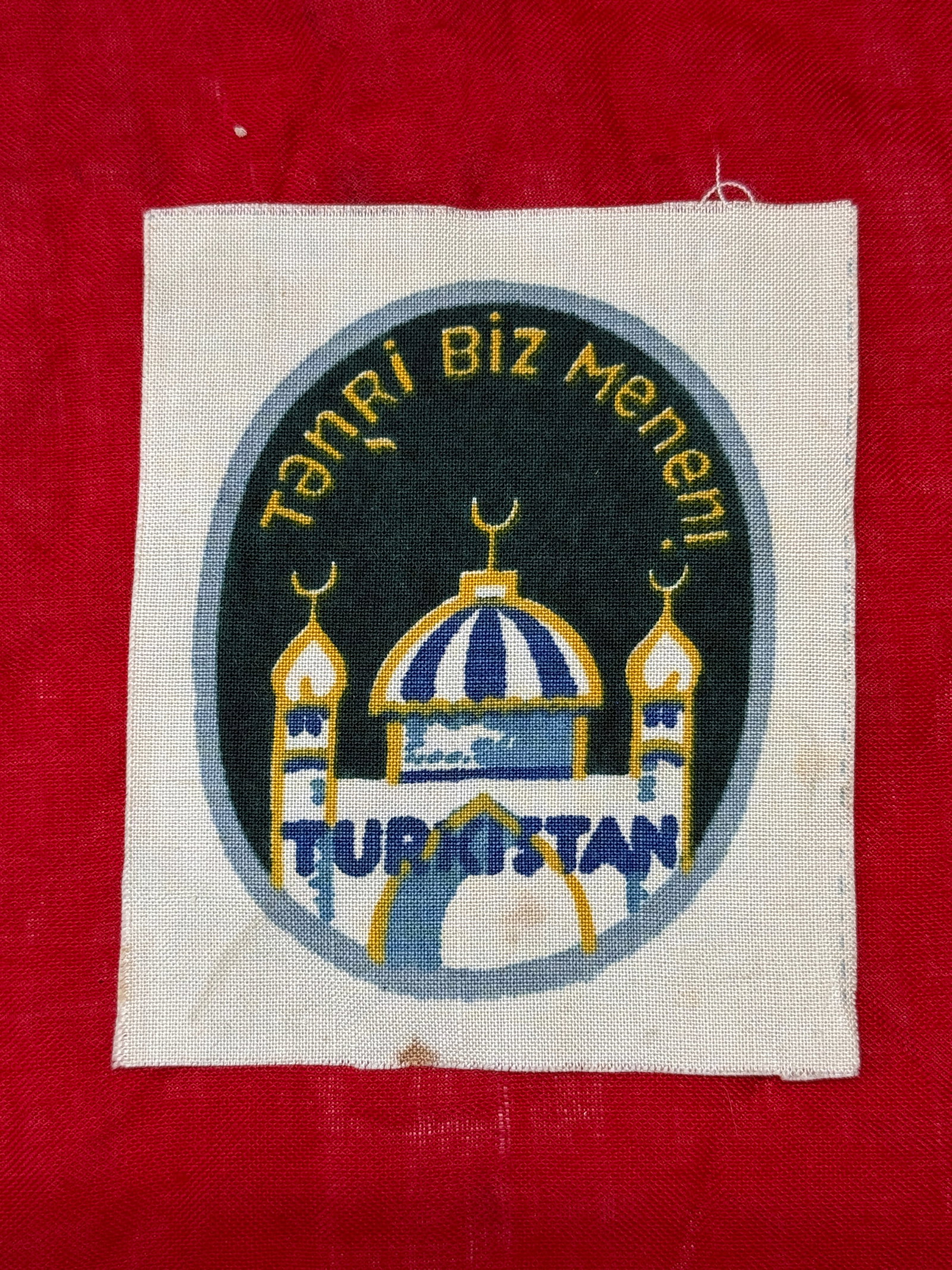 WWII Turkistan Legion "Tanri Biz Menen" Cloth Sleeve Insignia: This cloth sleeve insignia is attributed to the Turkistan Legion, a military formation composed primarily of Turkic volunteers serving under German command during the Second World War. The badge depic