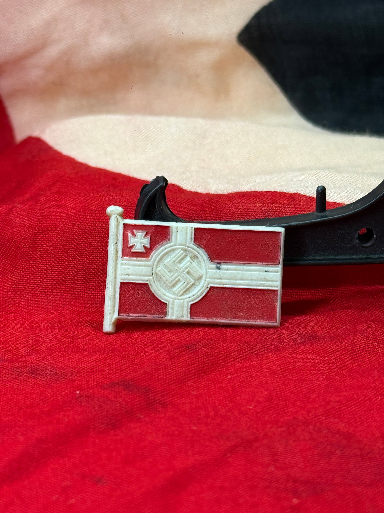 WWII German Reichskriegsflagge Miniature Flag Badge: This miniature badge is fashioned in the form of the Reichskriegsflagge (German War Flag) featuring a red field, white cross, central swastika emblem, and Iron Cross in the canton. The reverse is mark