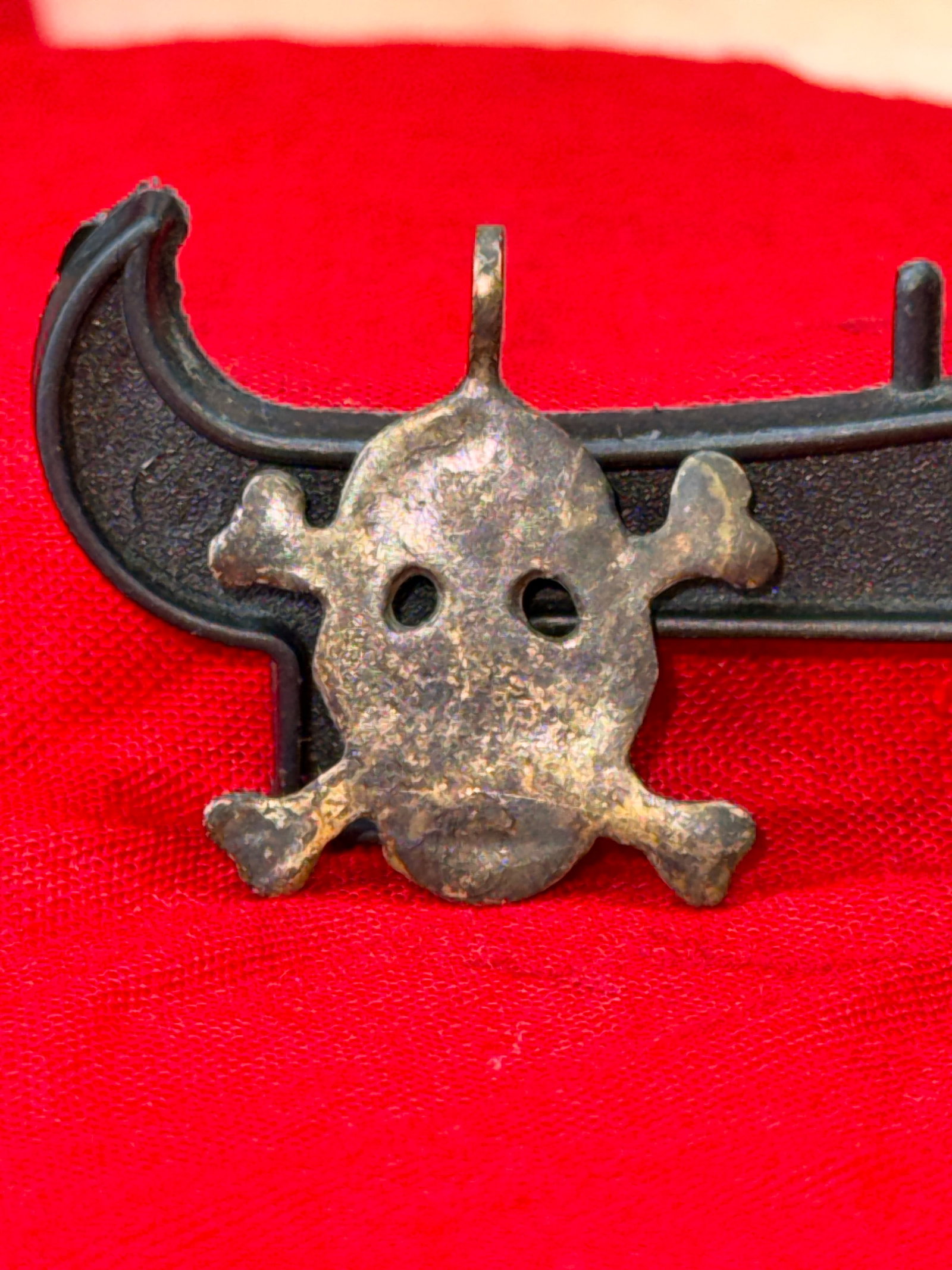 WWII German Totenkopf Silver Skull Pendant: This silver pendant is formed as the iconic Totenkopf skull and crossbones with pierced eye sockets and an integral suspension loop at the top for wear on a chain or cord. The reverse is plain, while 