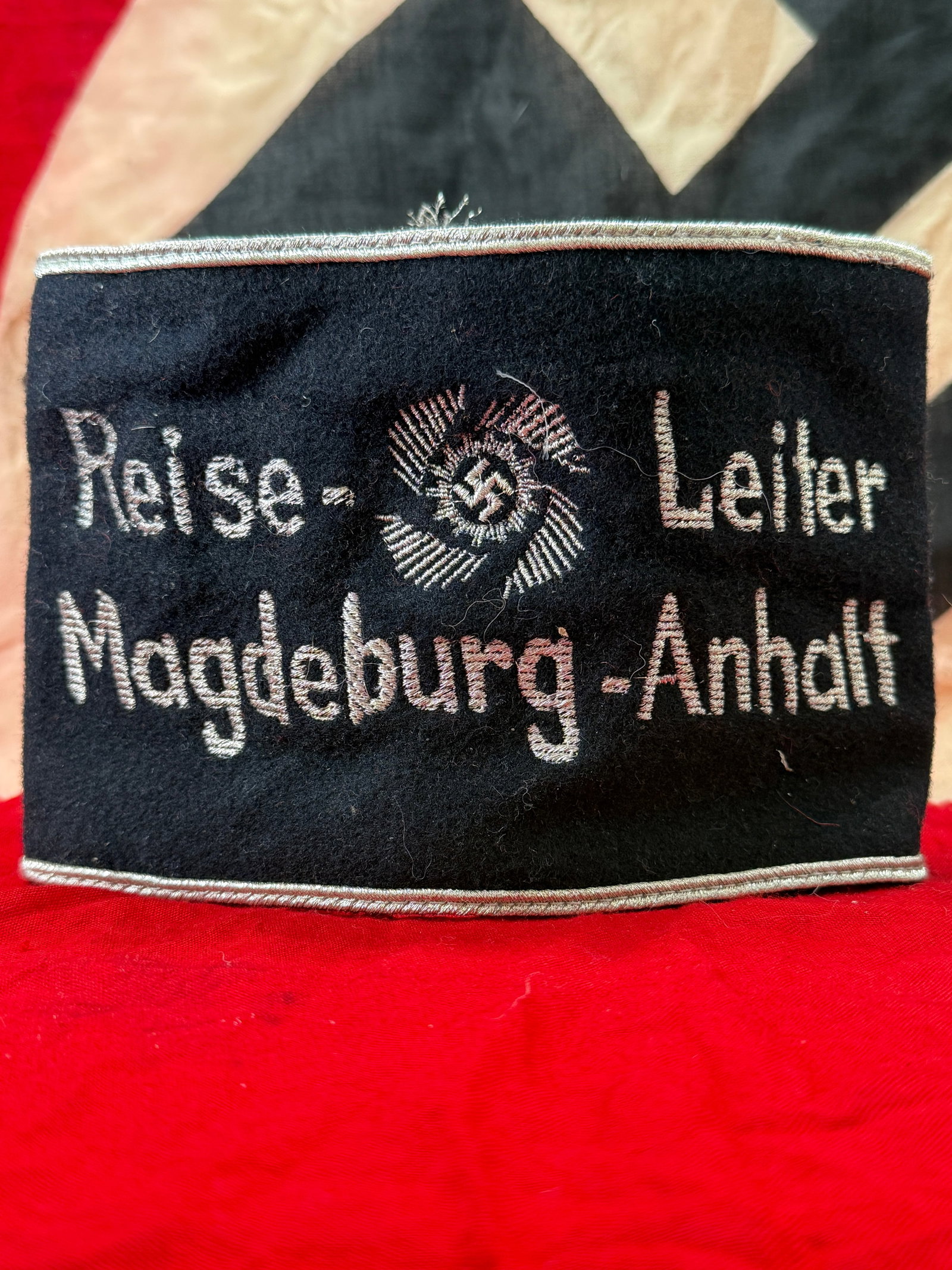 WWII German NSDAP Reise-Leiter Magdeburg-Anhalt Armband with RZM Tag: This black wool political armband is embroidered in silver-gray thread with the title "Reise-Leiter Magdeburg-Anhalt" surrounding a National Socialist emblem, identifying the wearer as a travel leader