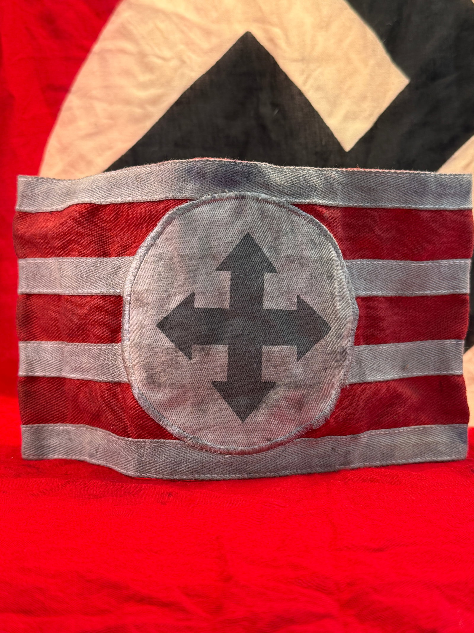WWII Hungarian Fascist Party Arrow Cross Party Armband: This WWII Hungarian Arrow Cross Party armband is constructed of red cloth with horizontal gray woven stripes and a centrally applied gray circular field displaying the distinctive black Arrow Cross em