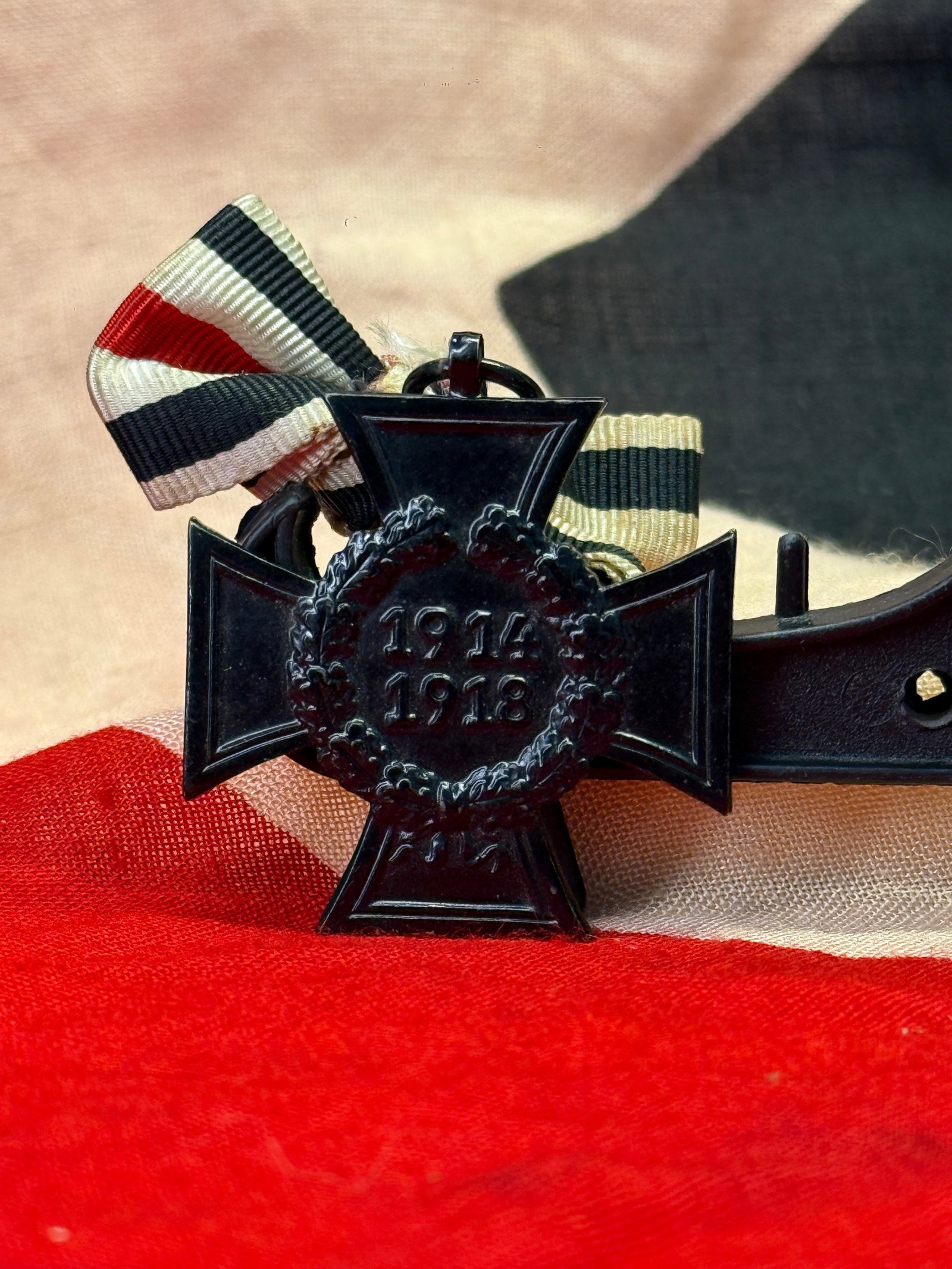 WWI German Hindenburg Cross Honor Medal With Ribbon: WWI German Hindenburg Cross honor medal for 1914–1918, finished in black with a laurel wreath center and dated “1914 1918” on the front. The medal is paired with its striped ribbon and the r