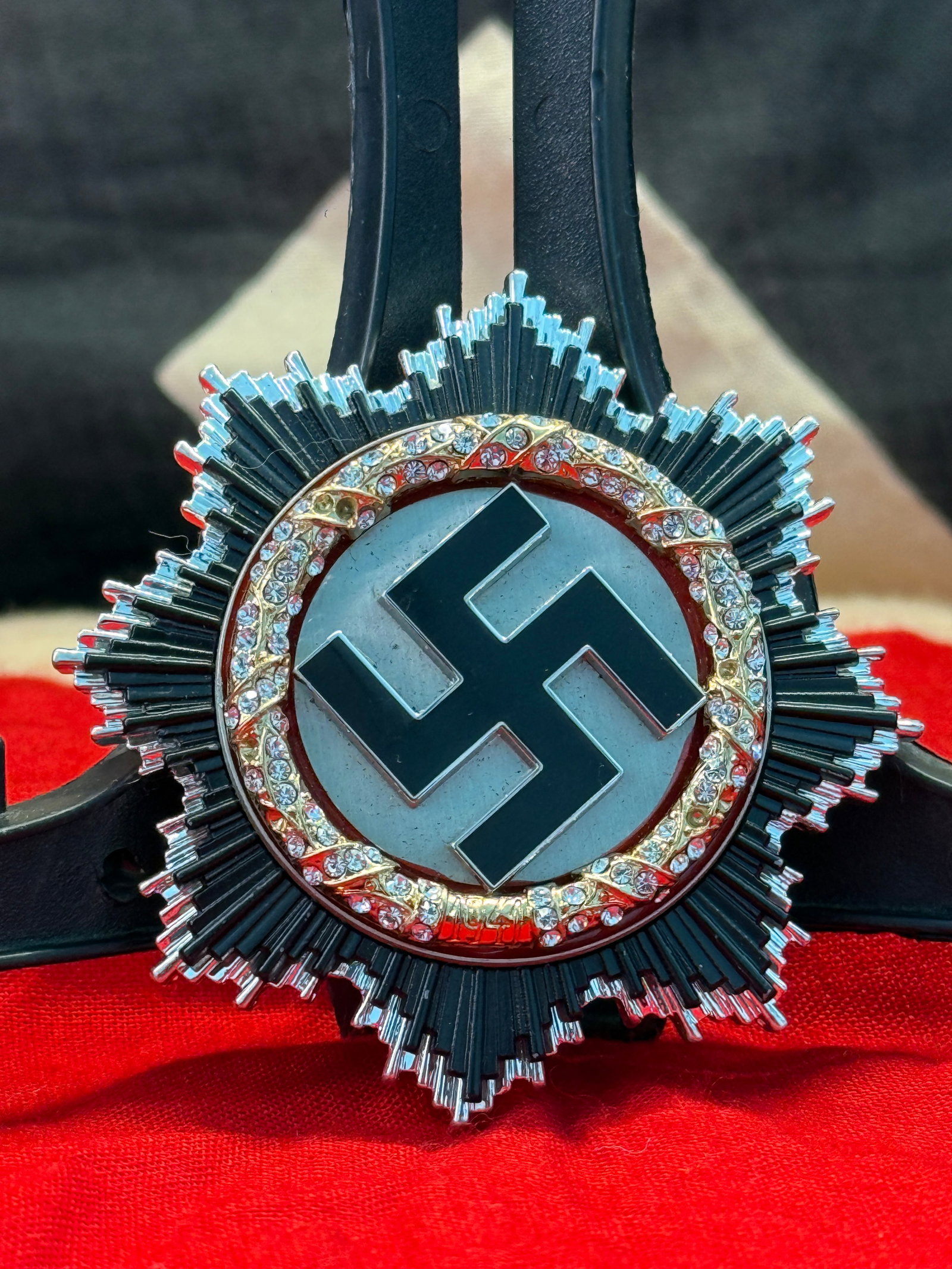 WWII German German Cross in Gold (Deutsches Kreuz in Gold): Multi-piece German Cross in Gold featuring a black enamel swastika centered within a gold wreath accented by faceted clear stones, all mounted on a silvered radiating starburst. The reverse retains it