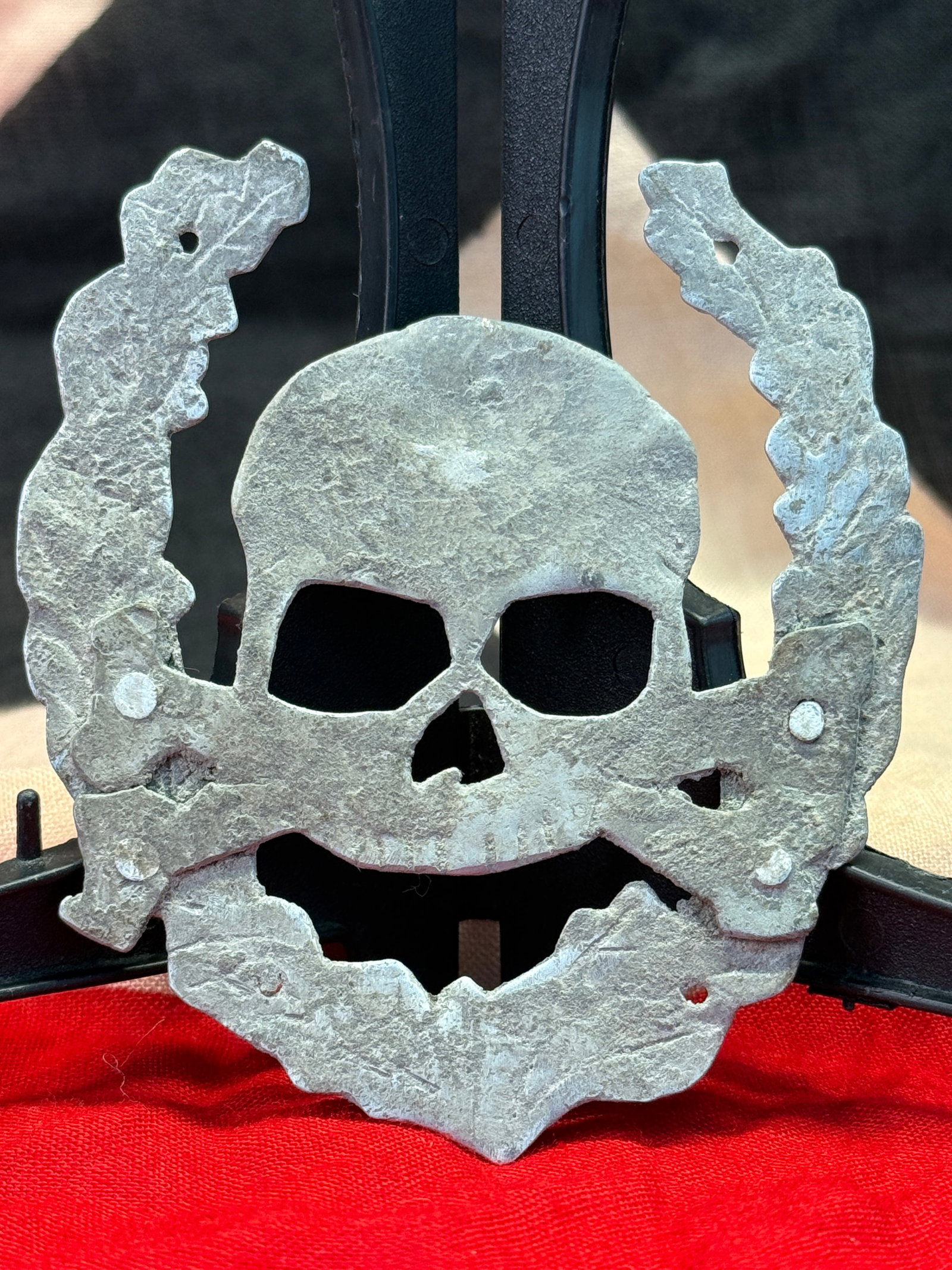 WWII German Waffen-SS Totenkopf Cap Insignia: The Totenkopf (Death's Head) was among the most recognizable insignia worn by the Waffen-SS during World War II. This example features the iconic skull and crossbones design secured by multiple attach
