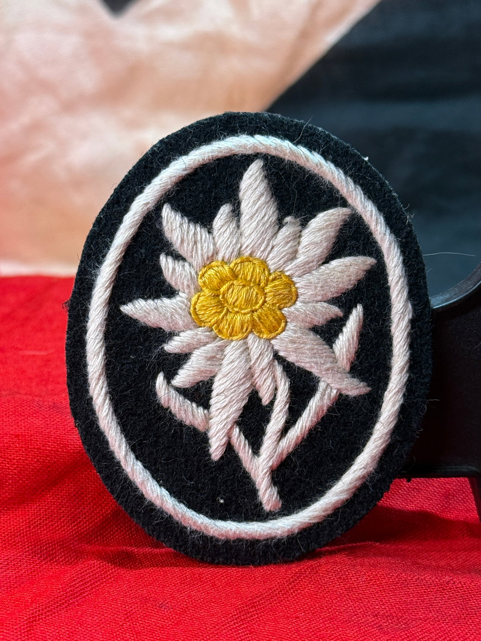 WWII German Waffen SS Edelweiss Sleeve Insignia: The Edelweiss flower served as the traditional insignia of German mountain troops (Gebirgsjäger) during the Second World War. This embroidered cloth insignia features a white Edelweiss blossom with a