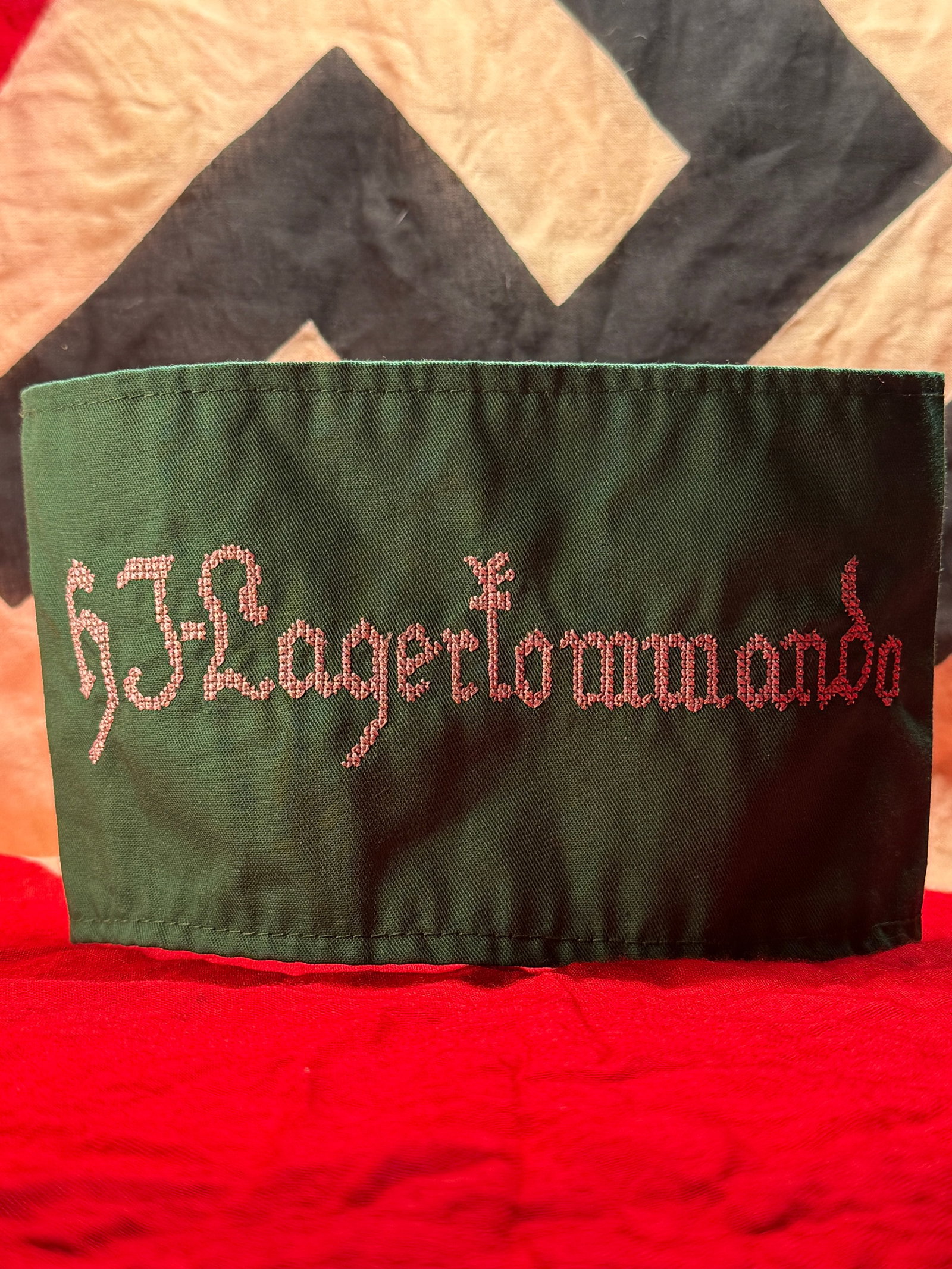 WWII German Hitlerjugend (Hitler Youth) Armband With RZM Paper Tag: This green cloth armband is embroidered with the script "HJ Lagertornando" and retains its original RZM (Reichszeugmeisterei) paper issue label inside, marked "Hersteller 14/931" with serial number 04
