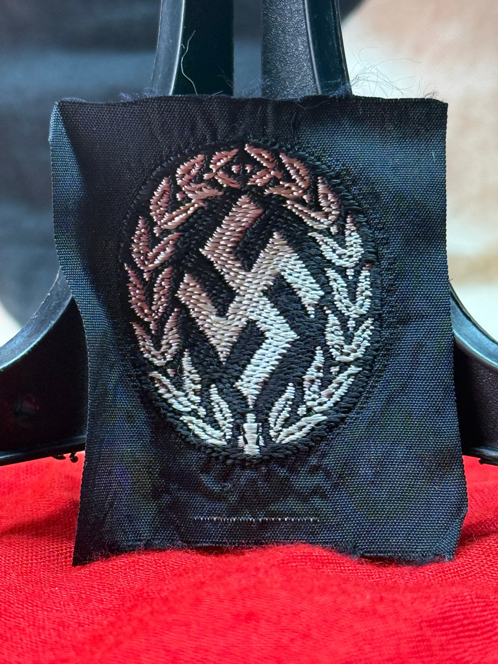 WWII German SA Sports Badge Cloth Uniform Patch: This embroidered oval cloth insignia depicts the SA Sports Badge design, featuring a vertical sword over a stylized wreath. The SA Sports Badge recognized proficiency in physical fitness, endurance, a