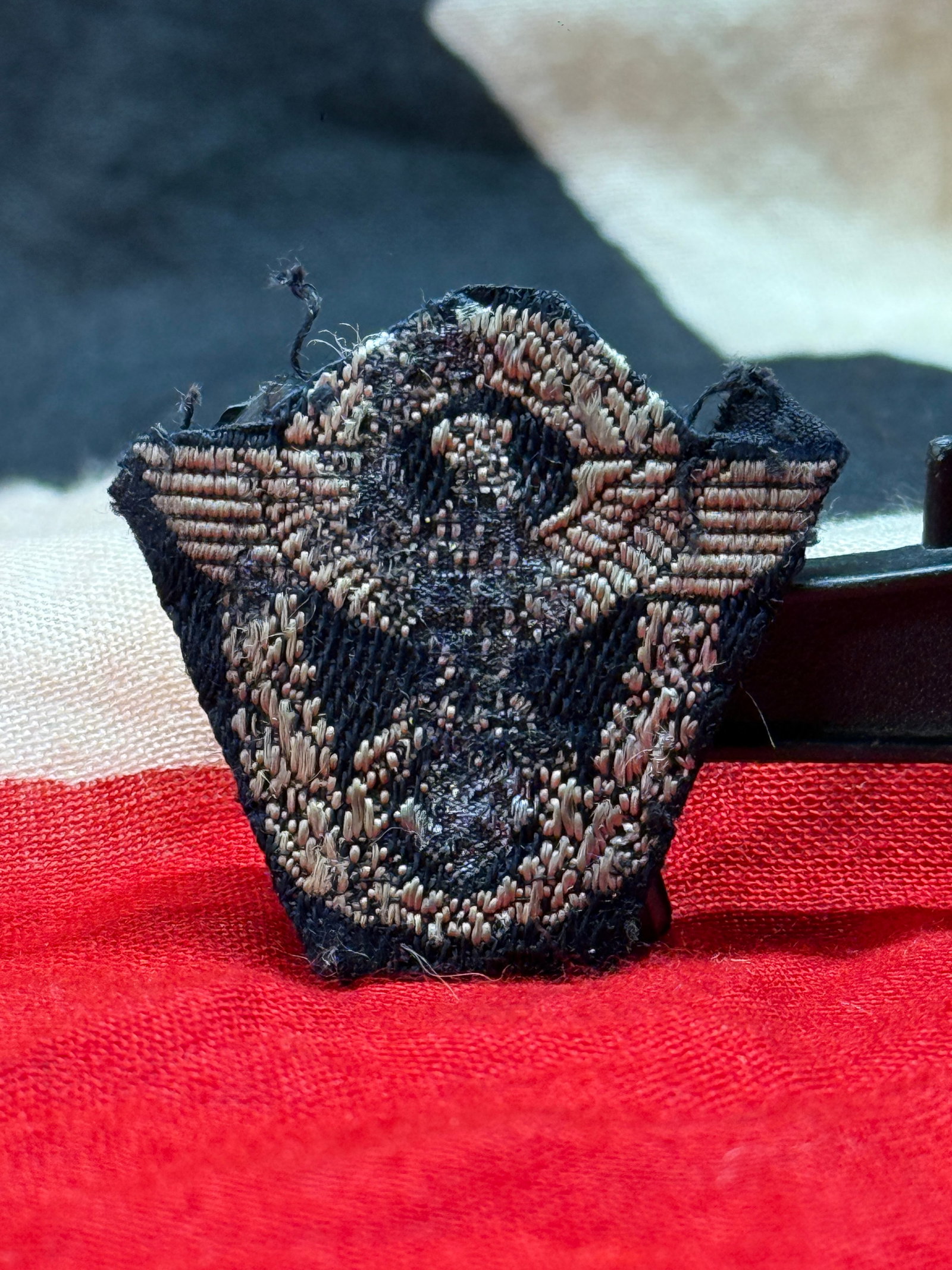WWII German SS-Police (Ordnungspolizei) Eagle Cap/Sleeve Insignia: This embroidered insignia depicts the German Police eagle with outstretched wings above a wreath enclosing a swastika, executed in silver-gray thread on a dark cloth backing. Insignia of this style we