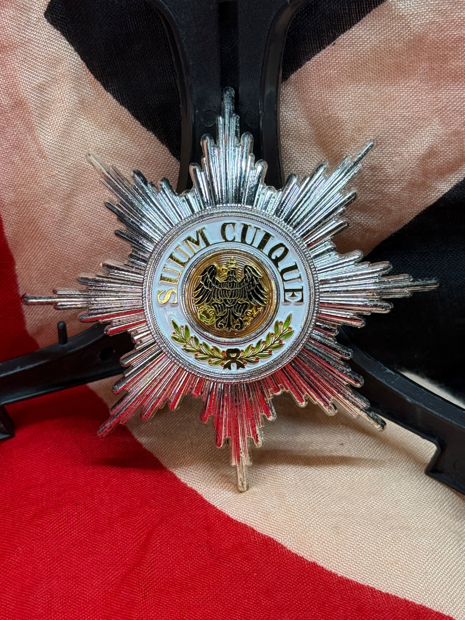 Imperial German Order of the Black Eagle Breast Star: This striking multi-rayed silvered breast star features the motto "SUUM CUIQUE" encircling the black Prussian eagle above an enameled laurel wreath. The reverse retains its original hinged vertical pi