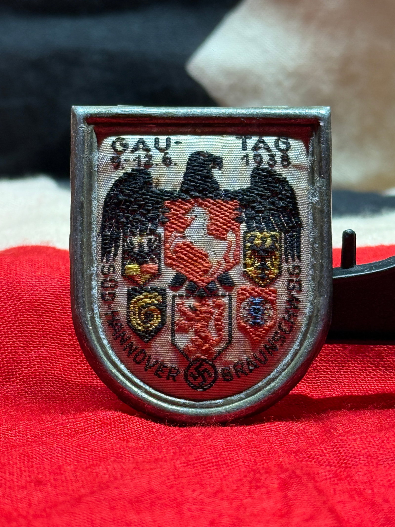 WWII German Gau Tag 1938 Hannover-Braunschweig Commemorative Badge: This celluloid-covered commemorative badge displays the regional coats of arms beneath a German eagle with the inscriptions "GAU-TAG 1938" and "DER HANNOVER-BRAUNSCHWEIG." The reverse retains its orig