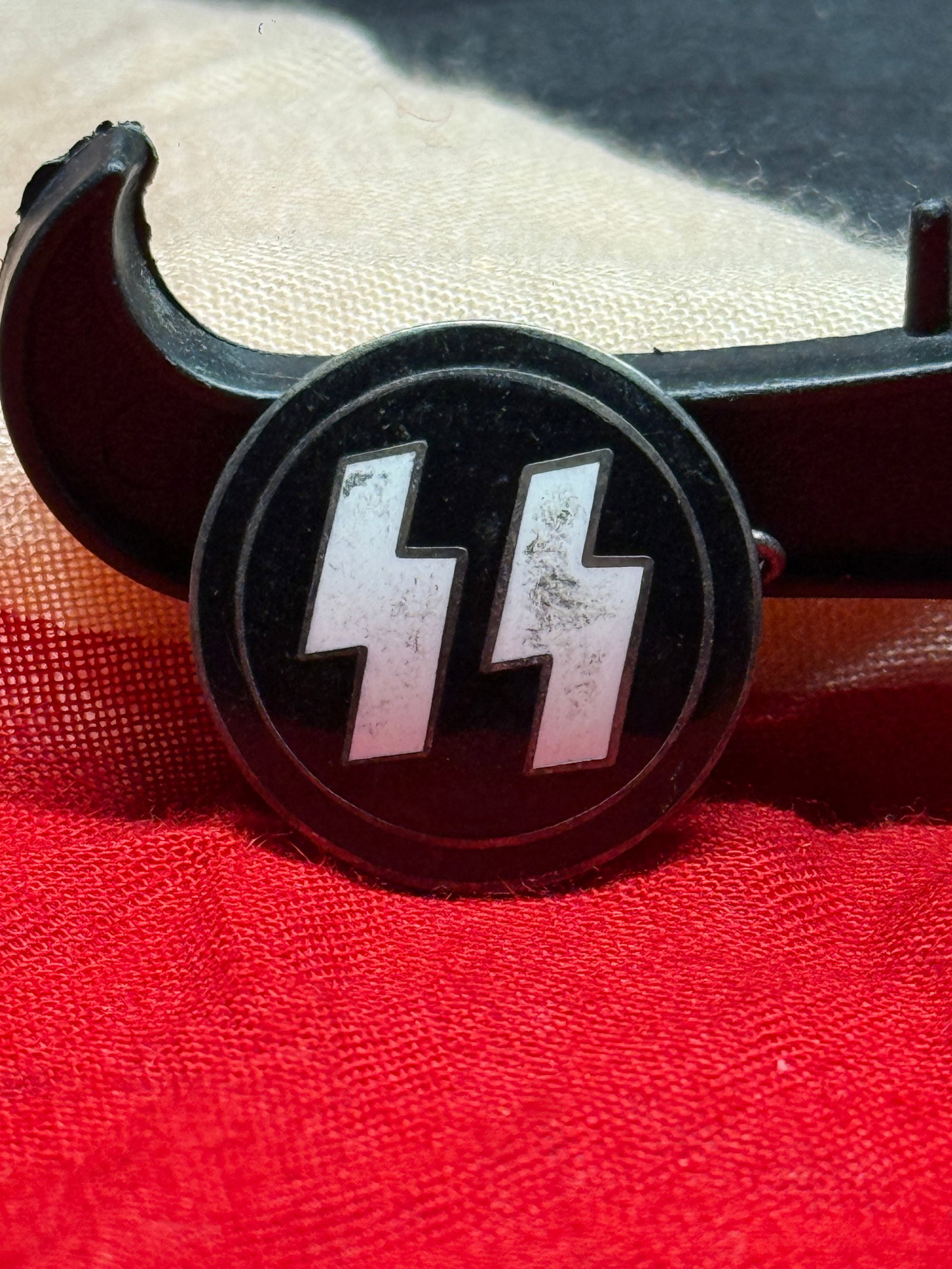 WWII German Waffen-SS Double Sig Rune Membership Lapel Pin By RZM M1/4 Ges. Gesch. Gesch.: This circular lapel pin features the iconic Waffen-SS double Sig rune insignia in silver against a black enamel background. The reverse is maker marked "RZM M1/4" with an additional "Ges. Gesch." (ges
