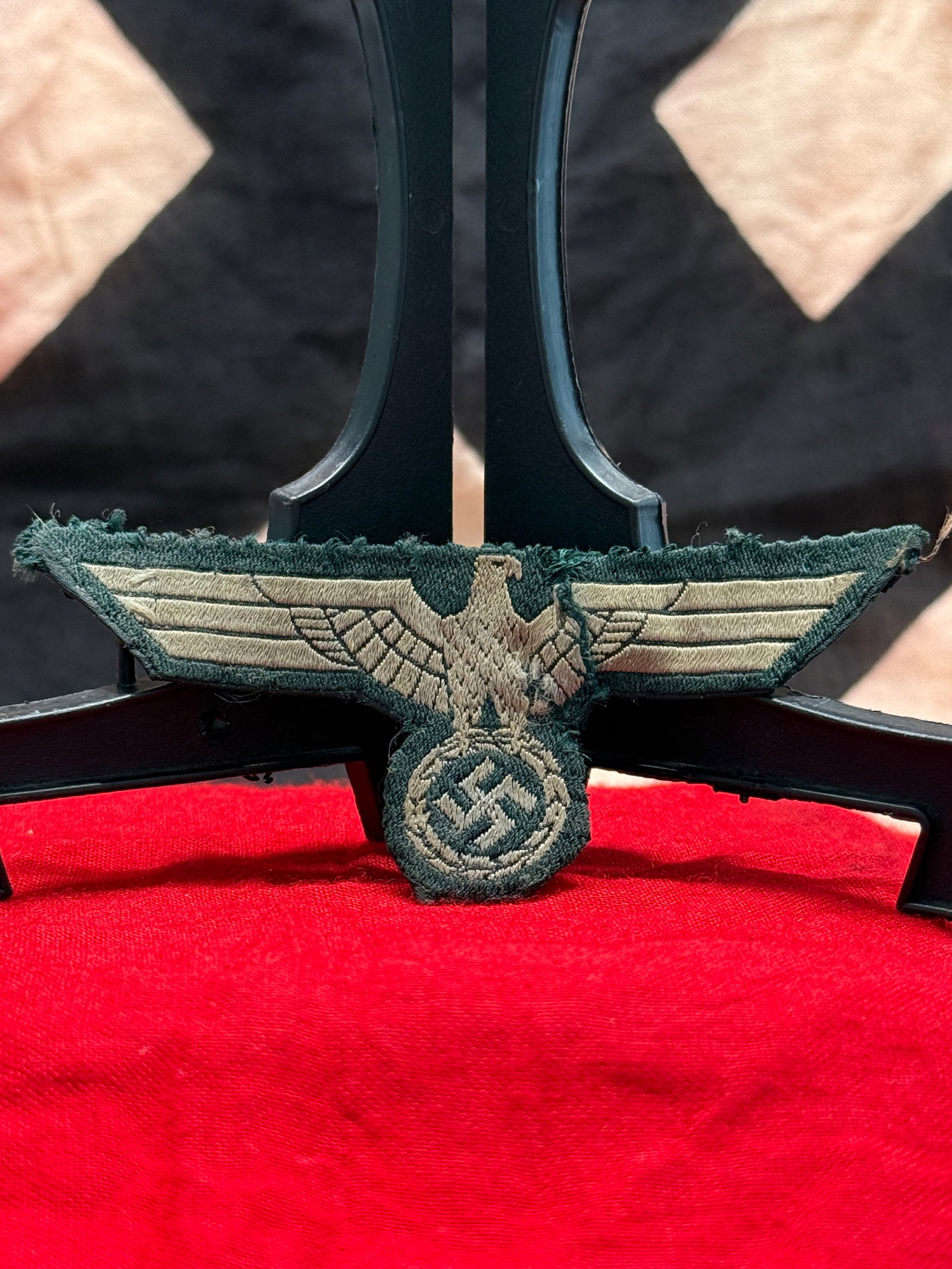 WWII German Heer (Army) Breast Eagle Patch: This WWII German Heer breast eagle patch is embroidered in silver-gray thread on a dark green wool backing and depicts the national eagle with outstretched wings clutching a wreath enclosing a swastik