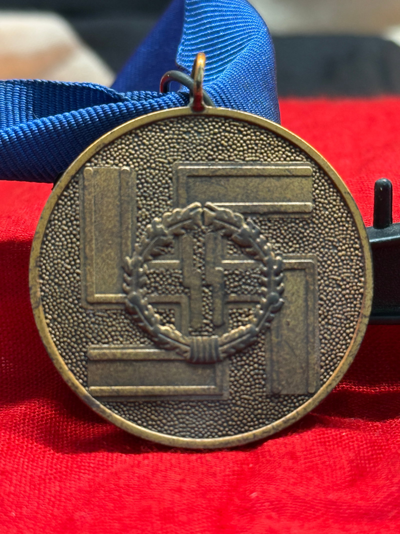 WWII German SS "Für Treue Dienste in der SS" Commemorative Medal: This WWII German SS commemorative medal is suspended from a blue ribbon and bears the inscription "Für Treue Dienste in der SS" ("For Faithful Service in the SS") surrounding the SS runes on one side
