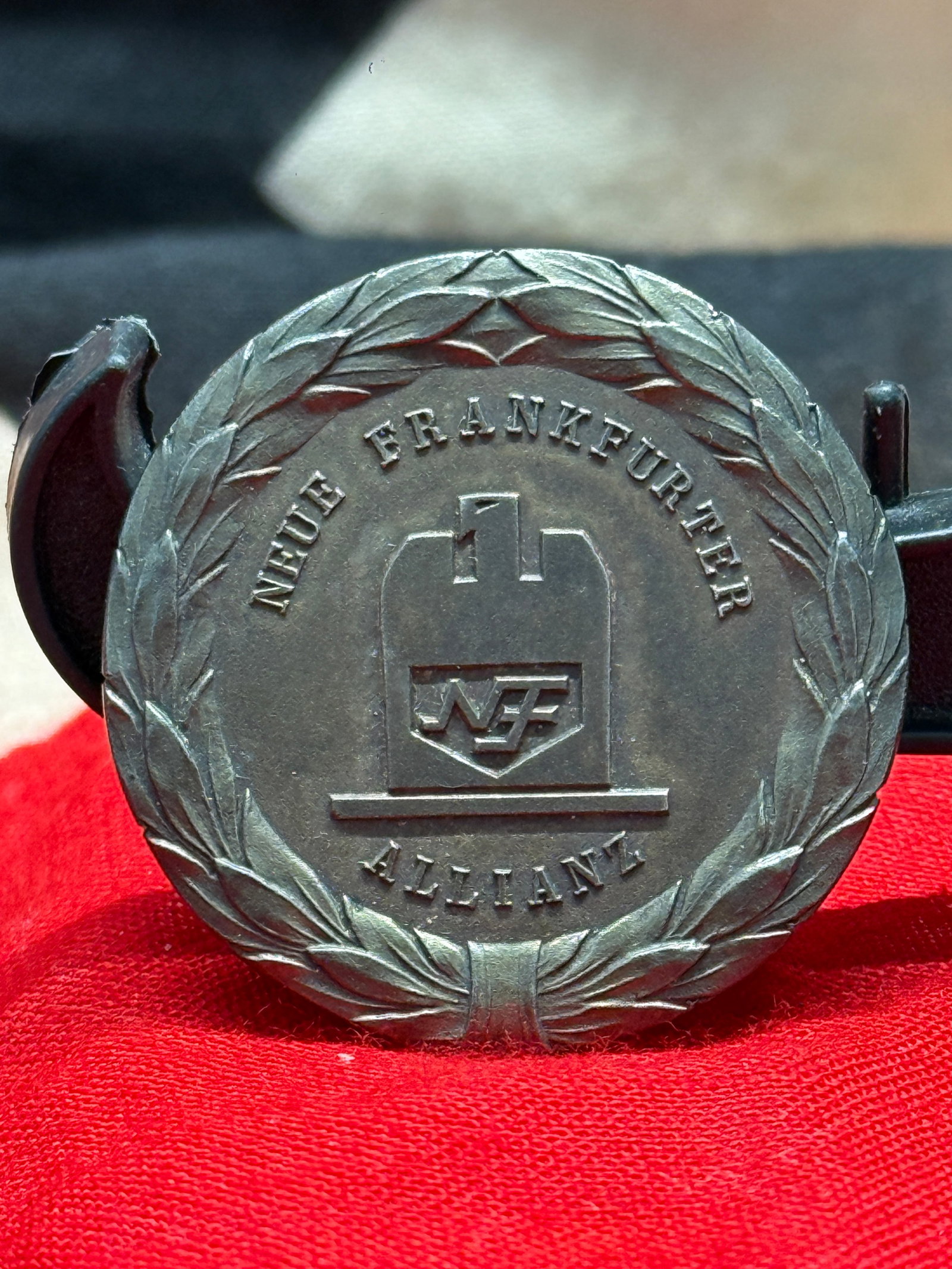 WW2 German Neue Frankfurter Allianz Employee Service Award Medal: This German employee service award medal was issued by Neue Frankfurter Allianz (NFA) and features the company's emblem within a laurel wreath on the obverse. The reverse bears the inscription "Dem ve