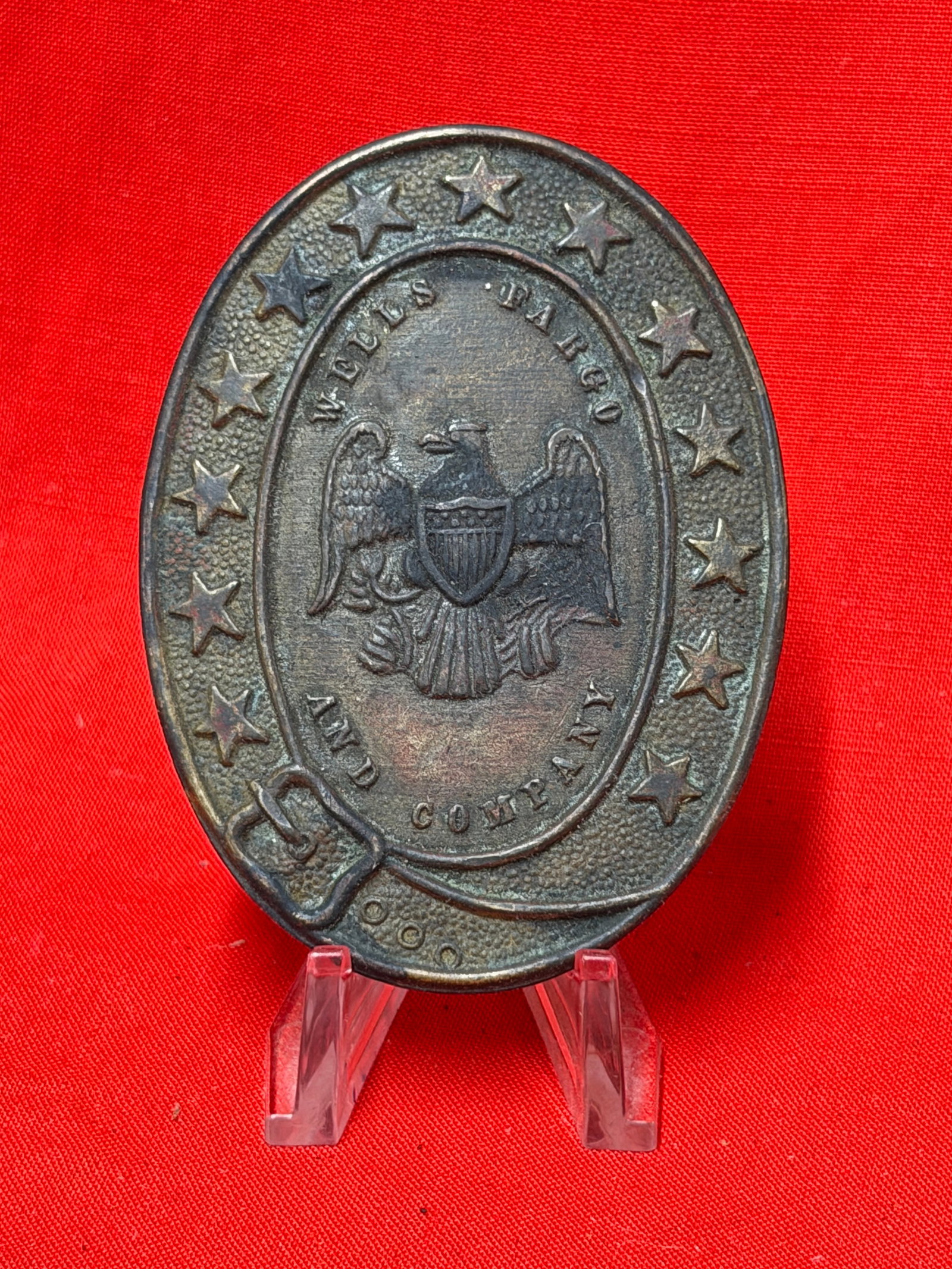 Civil War Union Wells Fargo & Company Belt Plate by Tiffany & Co.: This oval Civil War-era belt plate features the distinctive Wells Fargo and Company inscription surrounding a federal eagle with shield, enclosed by a border of raised stars. The reverse is stamped "T