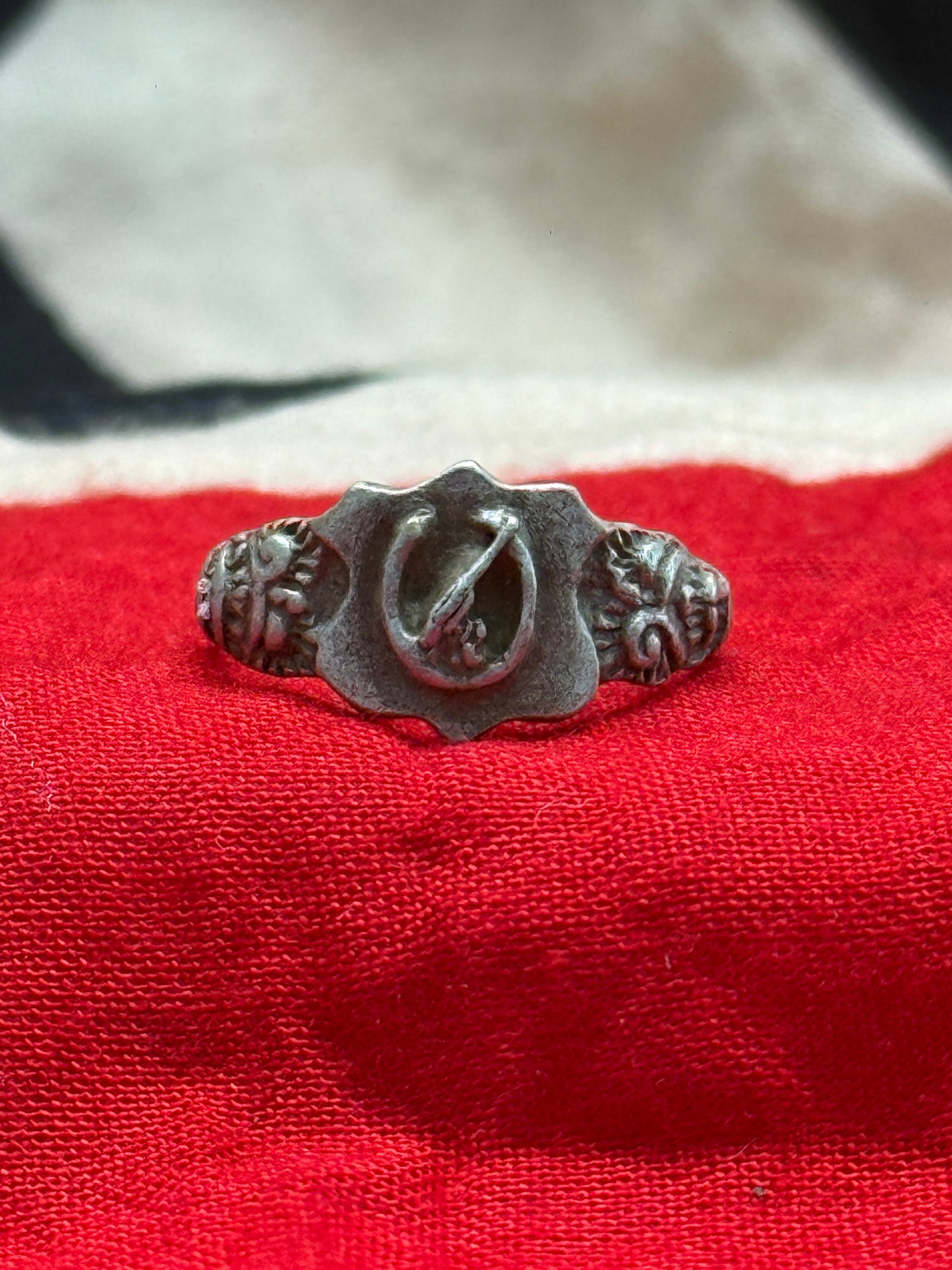 WWII German Heavy Artillery Officer Silver Ring: This WWII German Heavy Artillery Officer Silver Ring features a raised artillery shell and cannon barrel emblem within a scalloped center cartouche, flanked by ornate oak leaf and scrollwork motifs al