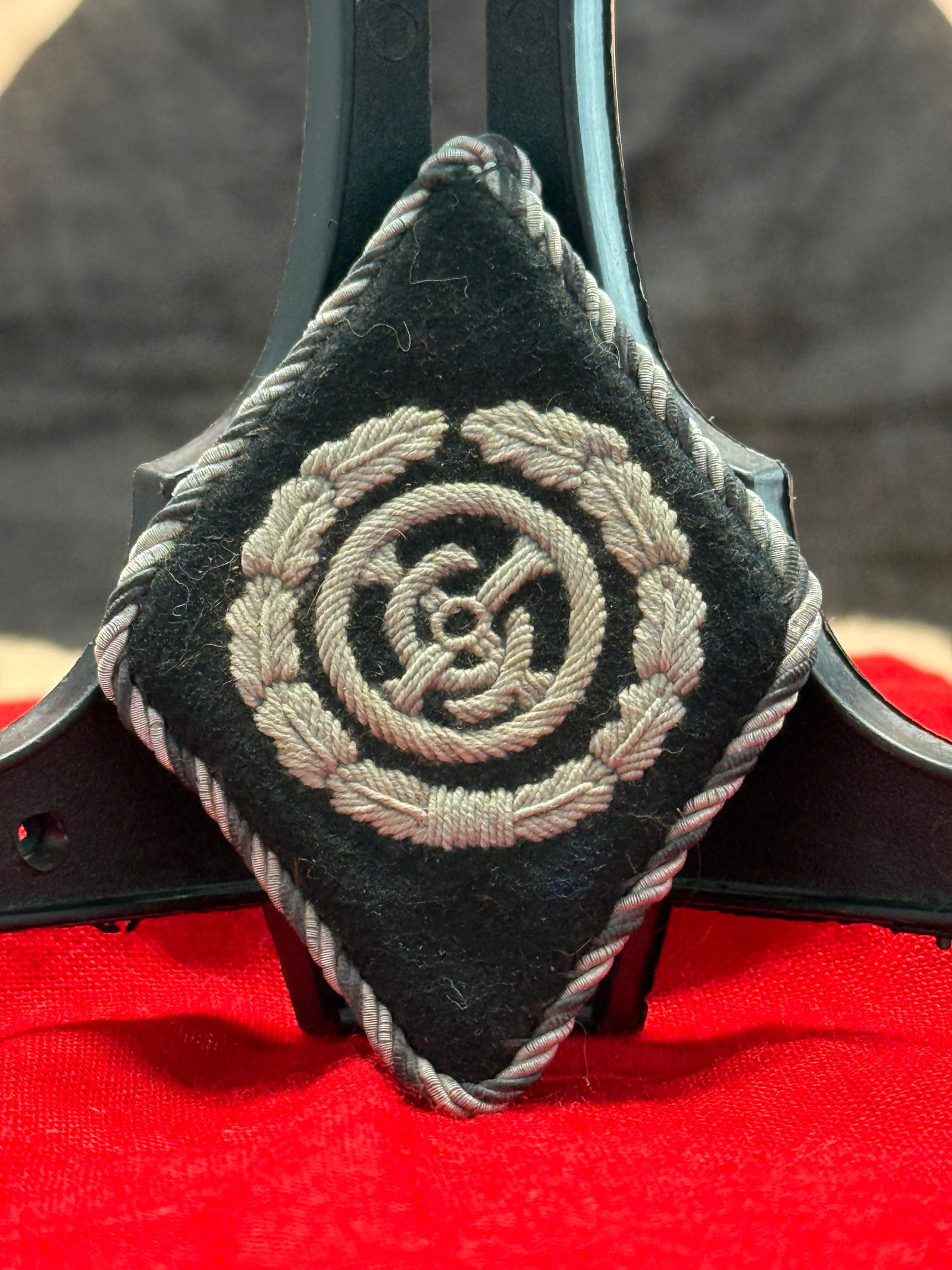 WWII German Kriegsmarine Coastal Artillery Sleeve Diamond Insignia: This embroidered diamond-shaped Kriegsmarine sleeve insignia features a silver bullion coastal artillery cannon encircled by an oak leaf wreath on a black wool backing with silver twisted cord edging.