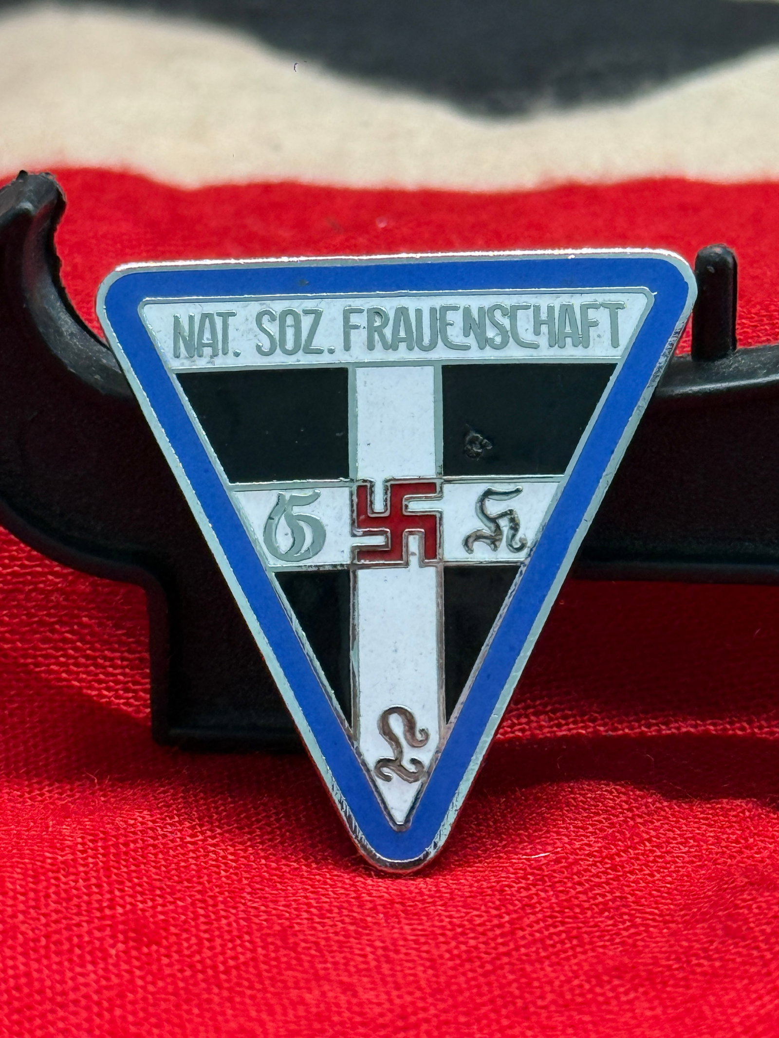 WWII German National Socialist Women's League (NS-Frauenschaft) Enamel Membership Badge: This triangular enameled badge represents the Nationalsozialistische Frauenschaft (NS-Frauenschaft), the official women's organization of the National Socialist Party. The front displays the organizat