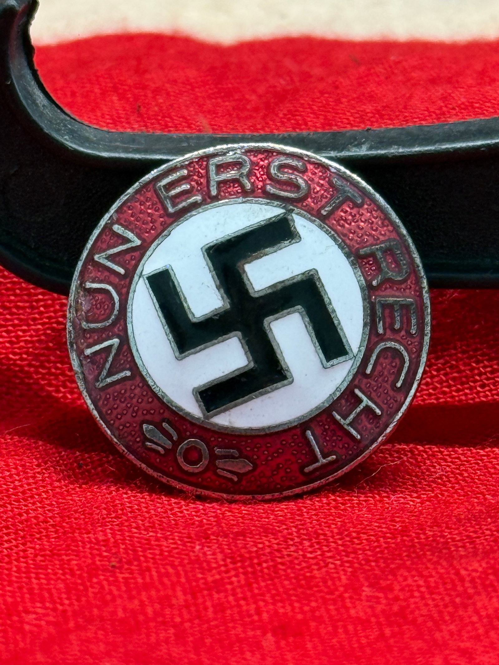 WWII German NSDAP Political Party Membership Badge (M1/17 Marked): This WWII German NSDAP Political Party Membership Badge features the iconic black swastika set within a white enamel field and surrounded by a red enamel border bearing the inscription "National-Sozia