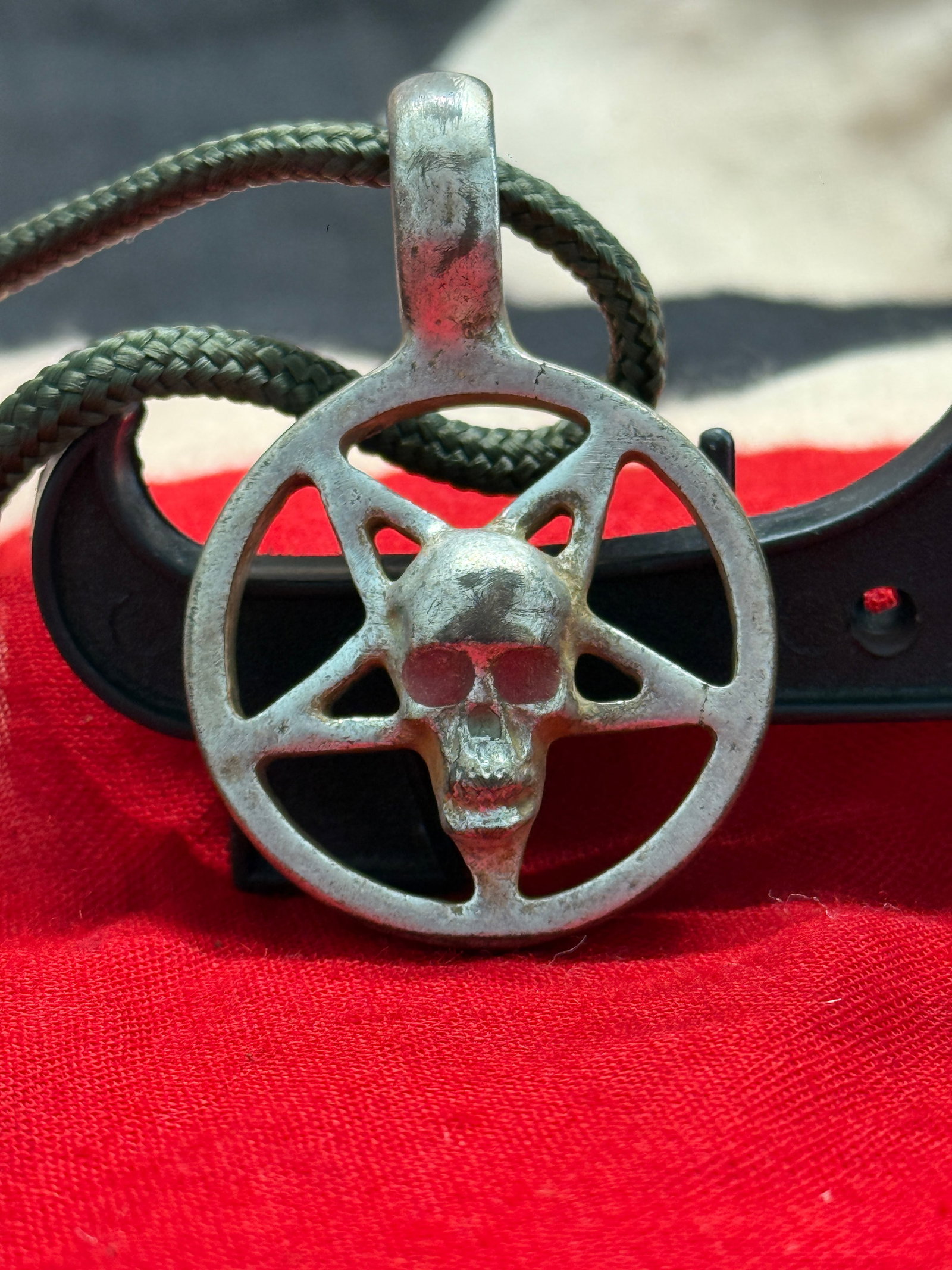 WWII German Totenkopf Pentagram Pendant: This cast metal pendant depicts a skull (Totenkopf) centered within a five-pointed star enclosed by a circular border, complete with an integral suspension loop for wear. The reverse displays the open