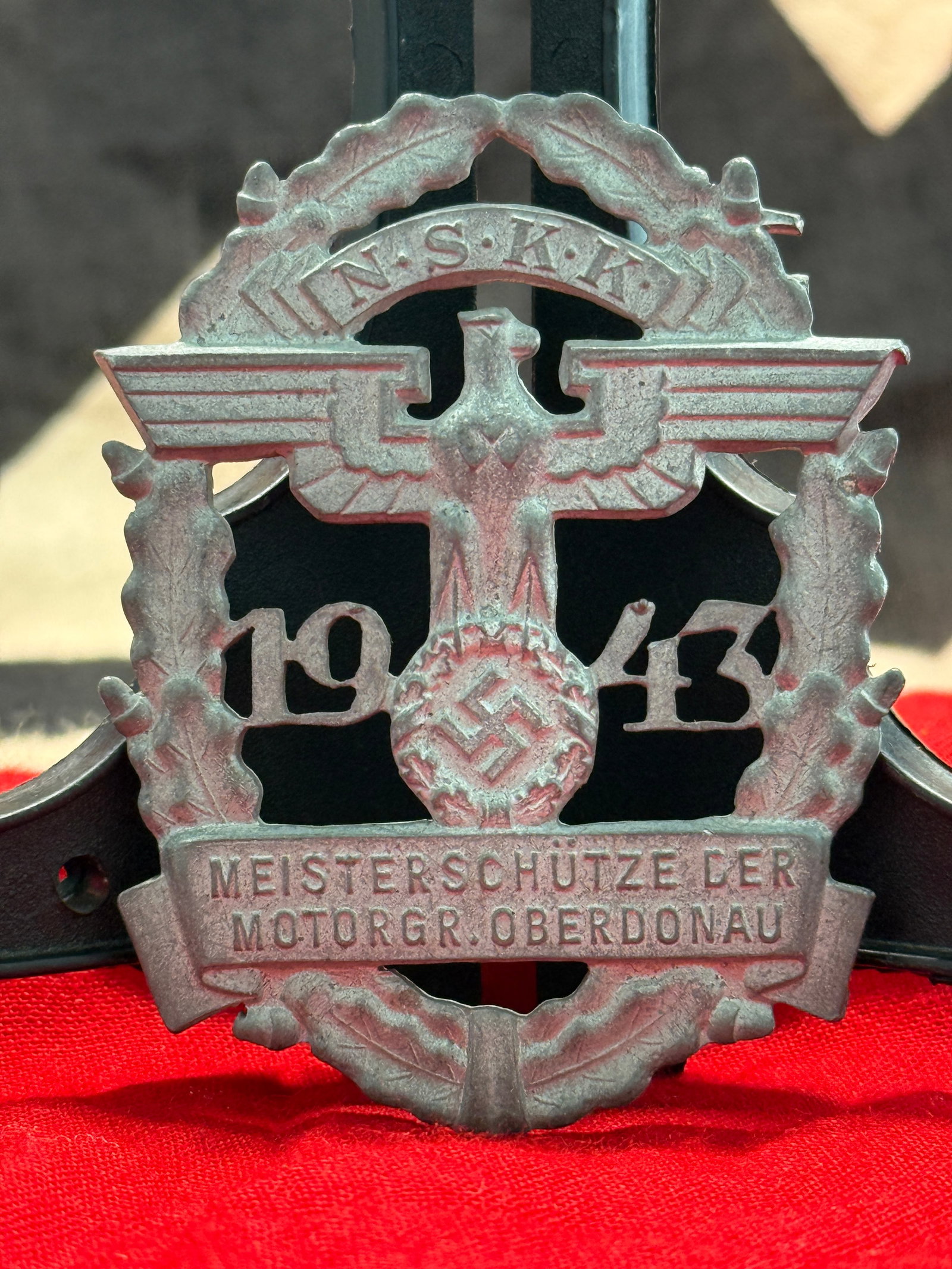 WWII German NSKK 1943 Meisterschütze Badge: This finely cast badge features an eagle above the date 1943, surrounded by an oak wreath and bearing the inscription “N.S.K.K. Meisterschütze der Motorgr. Oberdonau.” Award badges of this ty