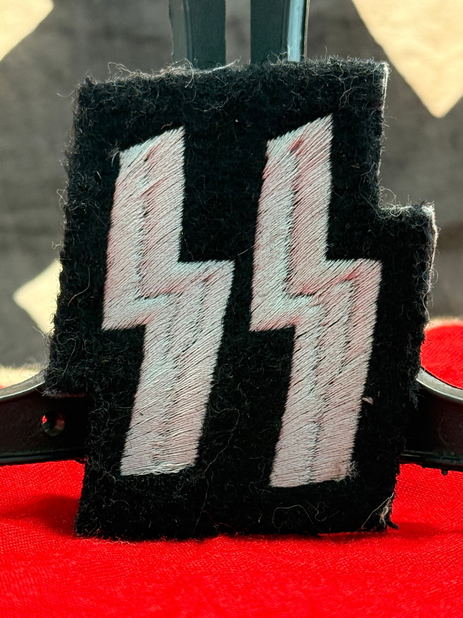 WWII German Waffen-SS SS Runes Sleeve Badge: This WWII German Waffen-SS SS Runes Sleeve Badge features the iconic pair of embroidered white SS runes on a black wool backing, designed for wear on the uniform sleeve as an identifying insignia. Con
