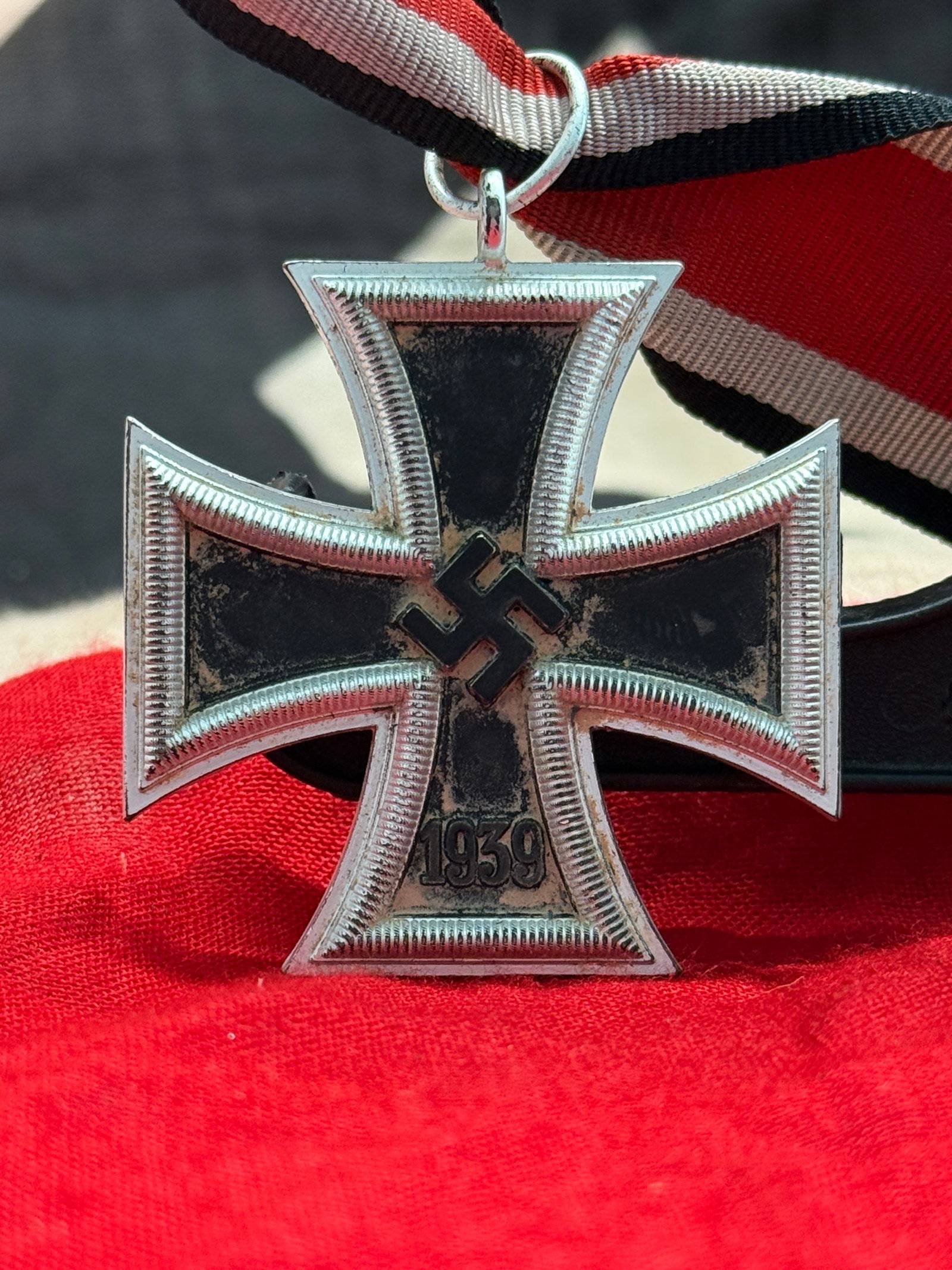 WWII German Iron Cross 2nd Class Medal (1939) With Ribbon: This medal is the 1939 Iron Cross 2nd Class, featuring a blackened iron core with a silvered frame, the swastika and date "1939" on the obverse, and the traditional "1813" date on the reverse commemor