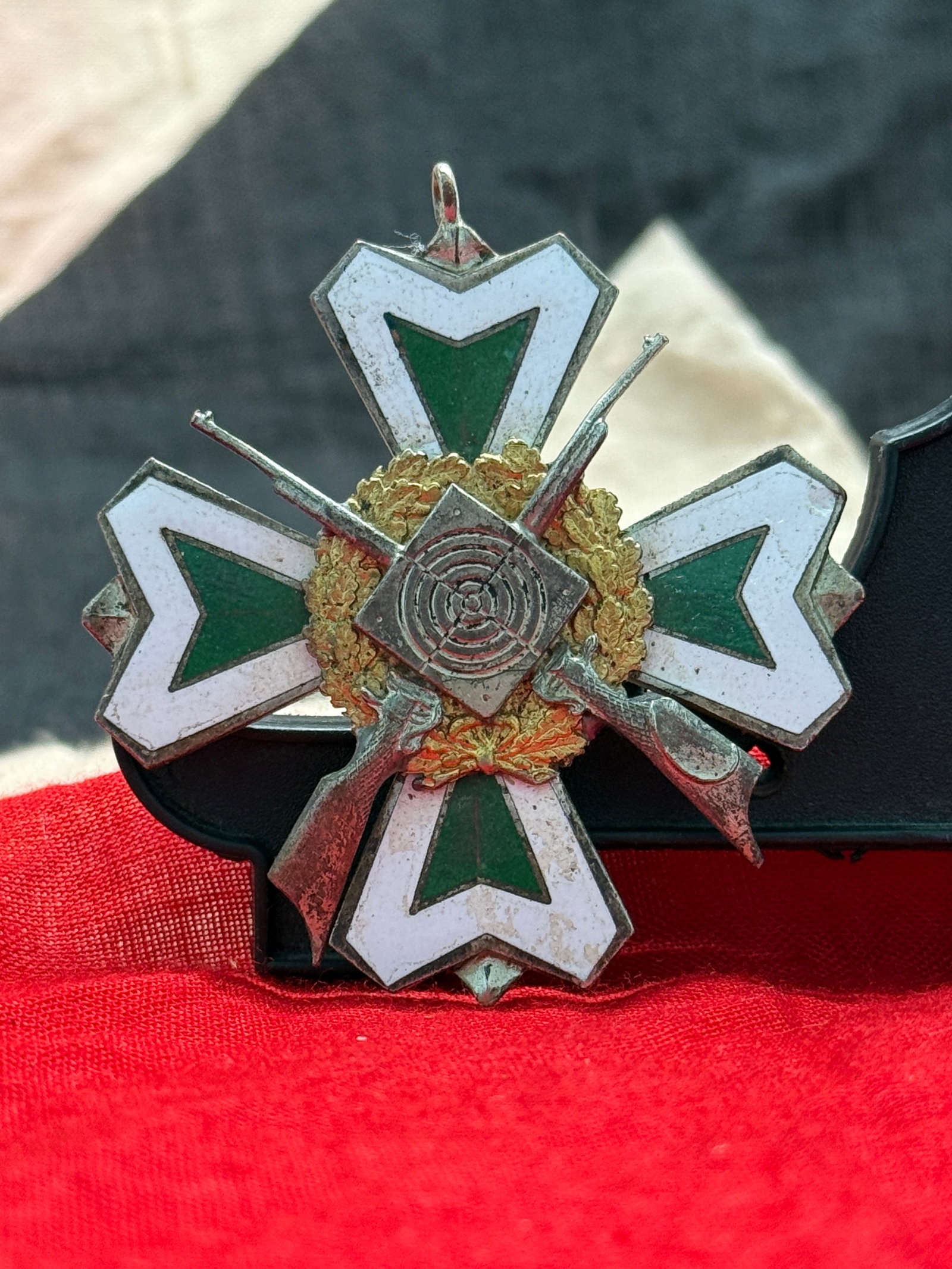 German Weimar Republic 1st Ritter Shooting Competition Prize Medal (1932): This ornate shooting award features a white and green enameled cross overlaid with crossed rifles, a target, and oak wreath, with the reverse engraved "1. Ritter 1932." Awarded during the Weimar Repub