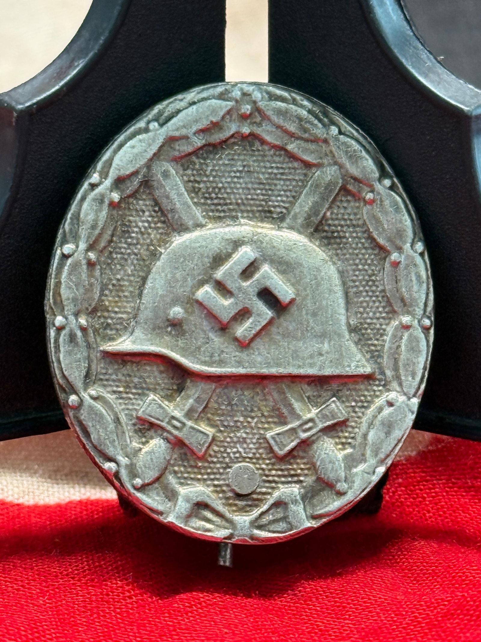 WWII German Silver Wound Badge (Verwundetenabzeichen in Silber): This German WWII Silver Wound Badge features the classic steel helmet with central swastika over crossed swords, all surrounded by an oak leaf wreath. The reverse retains its original vertical pinback