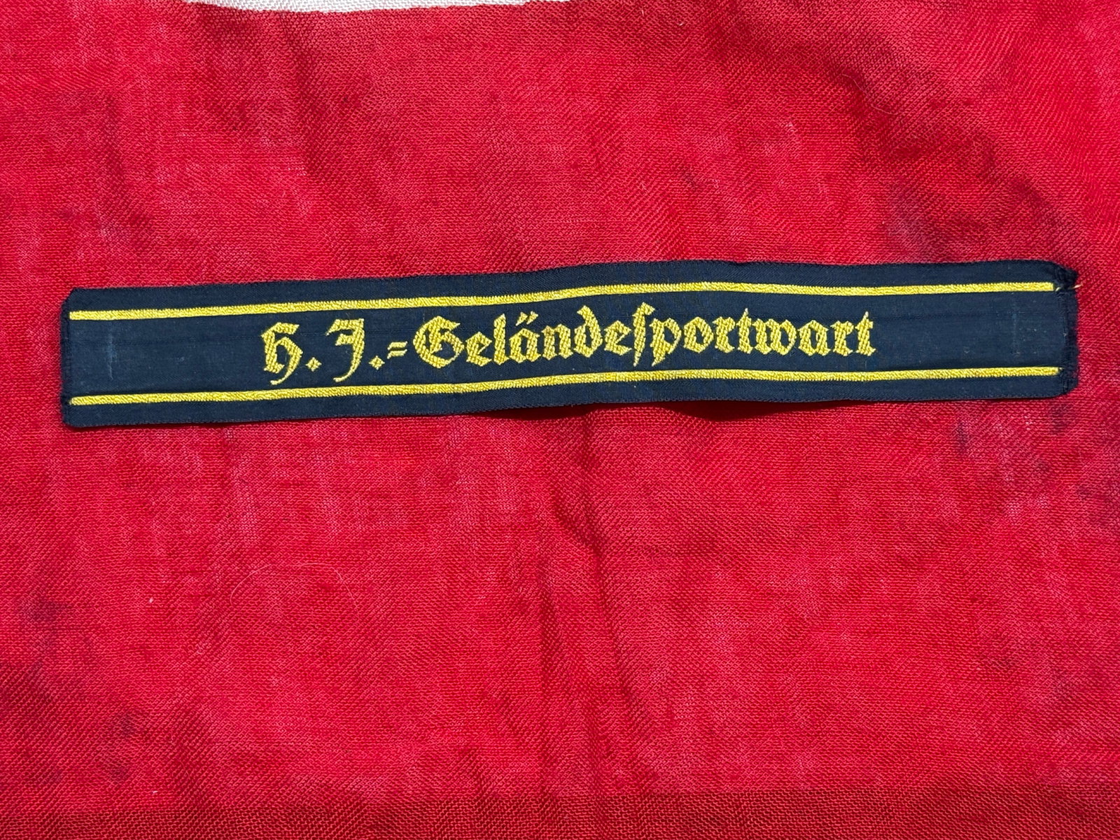 WWII German SS "Der Führer" Cuff Title: This German WWII SS cuff title is embroidered in gold Gothic script with the inscription "Der Führer" on a black woven backing with gold edge stripes. The title was worn by members of the Waffen-SS R