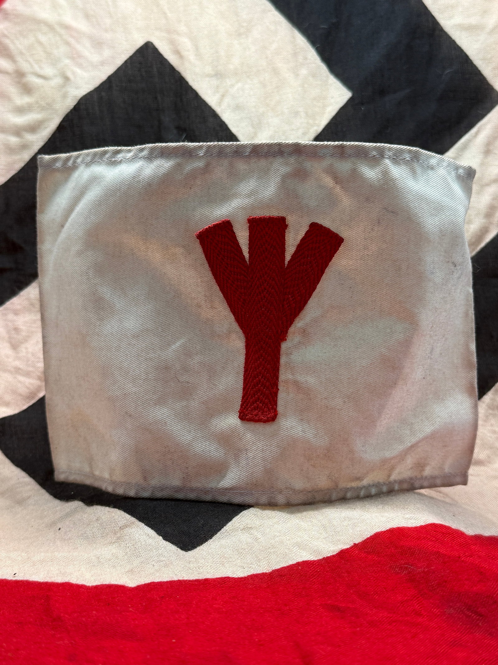 WWII German Hitler Youth (HJ) Medic Armband: This WWII German Hitler Youth (HJ) Medic Armband is constructed of white cloth and features a red embroidered medical service emblem affixed to the front. Worn by members assigned to first aid and med
