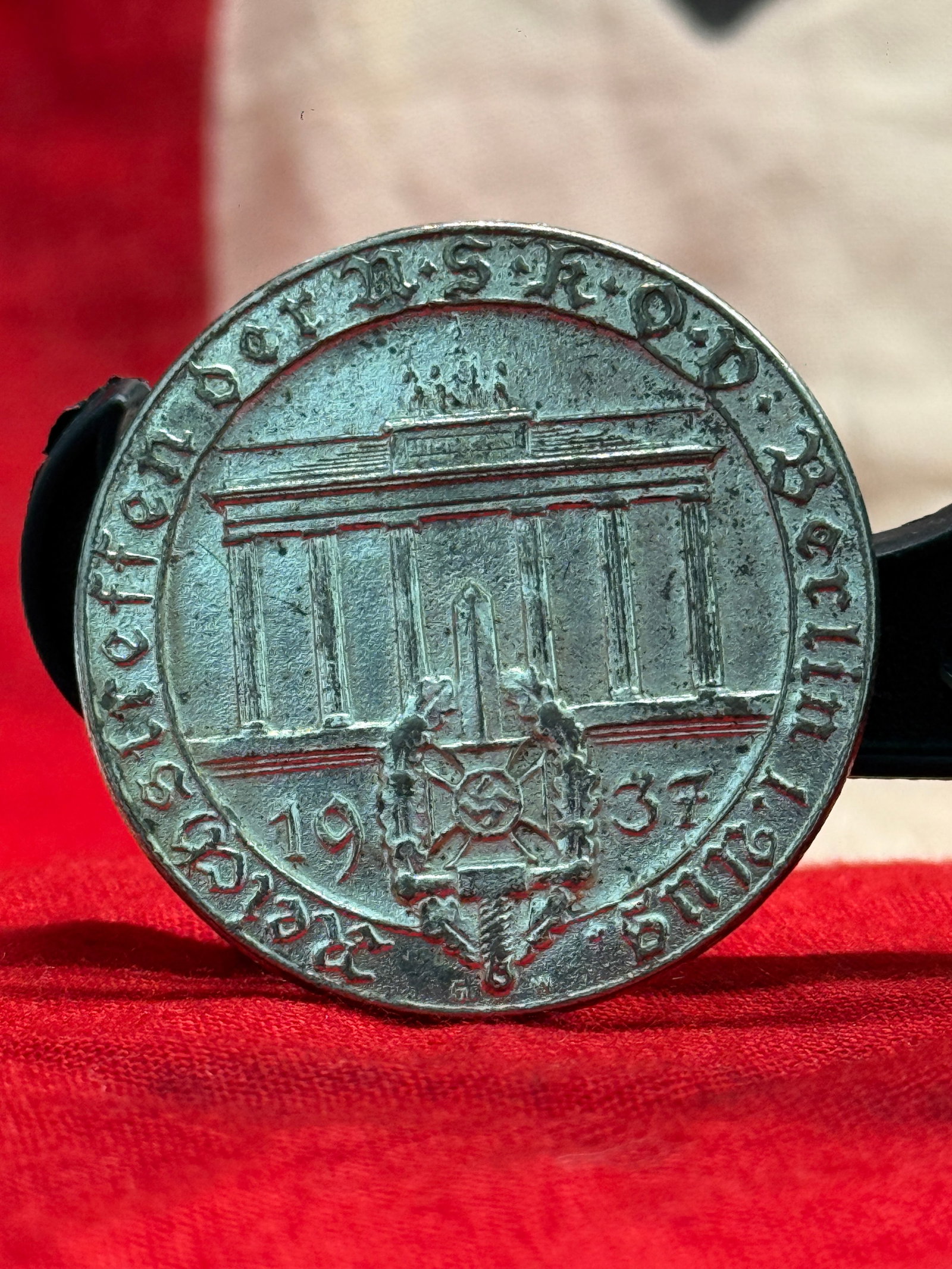 WWII German 1937 NSDAP Reichsparteitag Nürnberg Tinnie Badge: This circular commemorative badge marks the 1937 Reich Party Rally (Reichsparteitag) held in Nürnberg, Germany. The obverse depicts the Brandenburg Gate above the date "1937" with the event inscripti