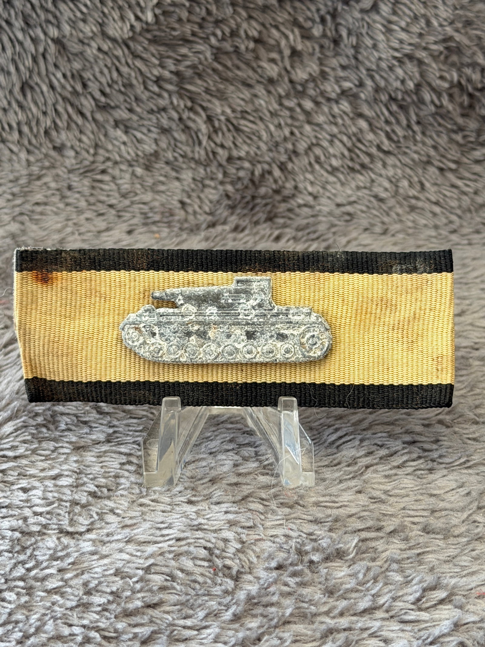 WWII German Panzer Assault Ribbon Bar with Tank Device: This WWII German Panzer Assault ribbon bar features a black-and-white ribbon mounted with a silver-toned miniature tank device representing armored warfare service. Ribbon bars such as this were worn 