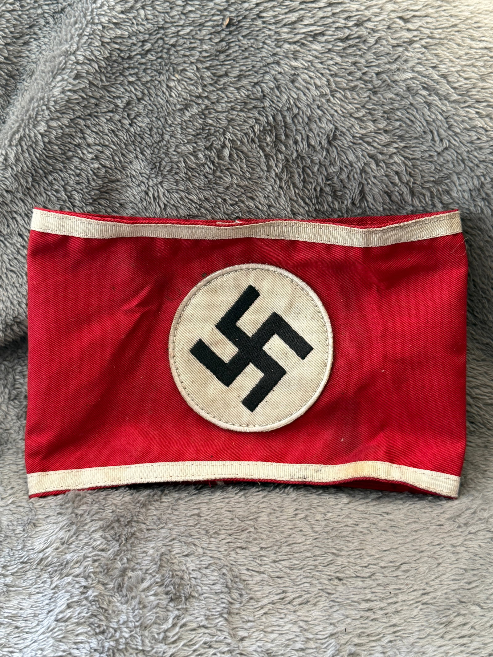 WWII German NSDAP Political Leader Red Armband with RZM Tag: This WWII German NSDAP Political Leader Red Armband is constructed of red fabric with white edge borders and features a separately applied white roundel with a black swastika embroidered at the center