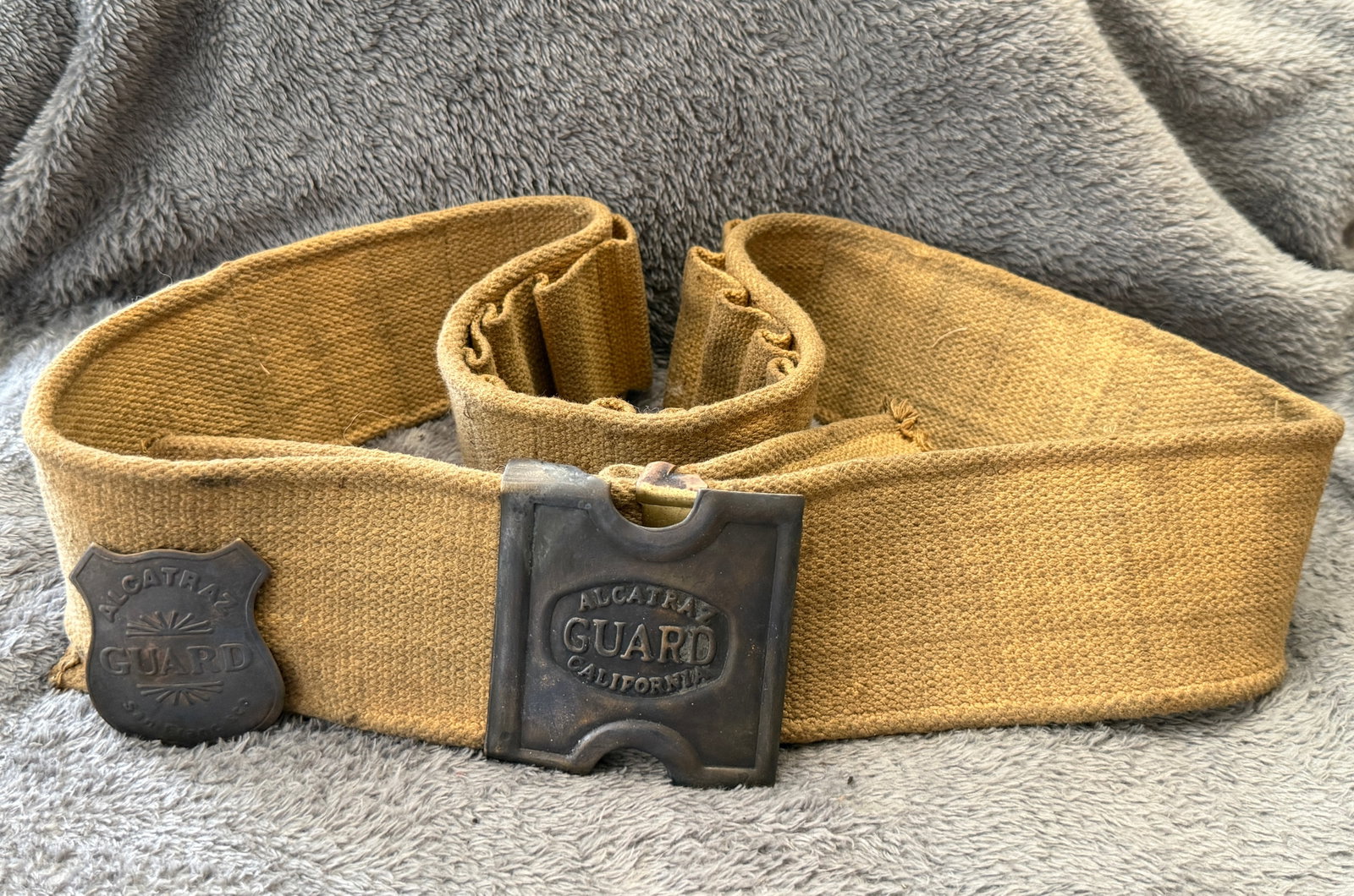 Historic Alcatraz Federal Penitentiary Guard Cartridge Belt, Buckle & Badge Set: This Historic Alcatraz Federal Penitentiary Guard Cartridge Belt, Buckle & Badge Set includes a heavy-duty khaki canvas cartridge belt fitted with an embossed "ALCATRAZ GUARD CALIFORNIA" brass buckle 