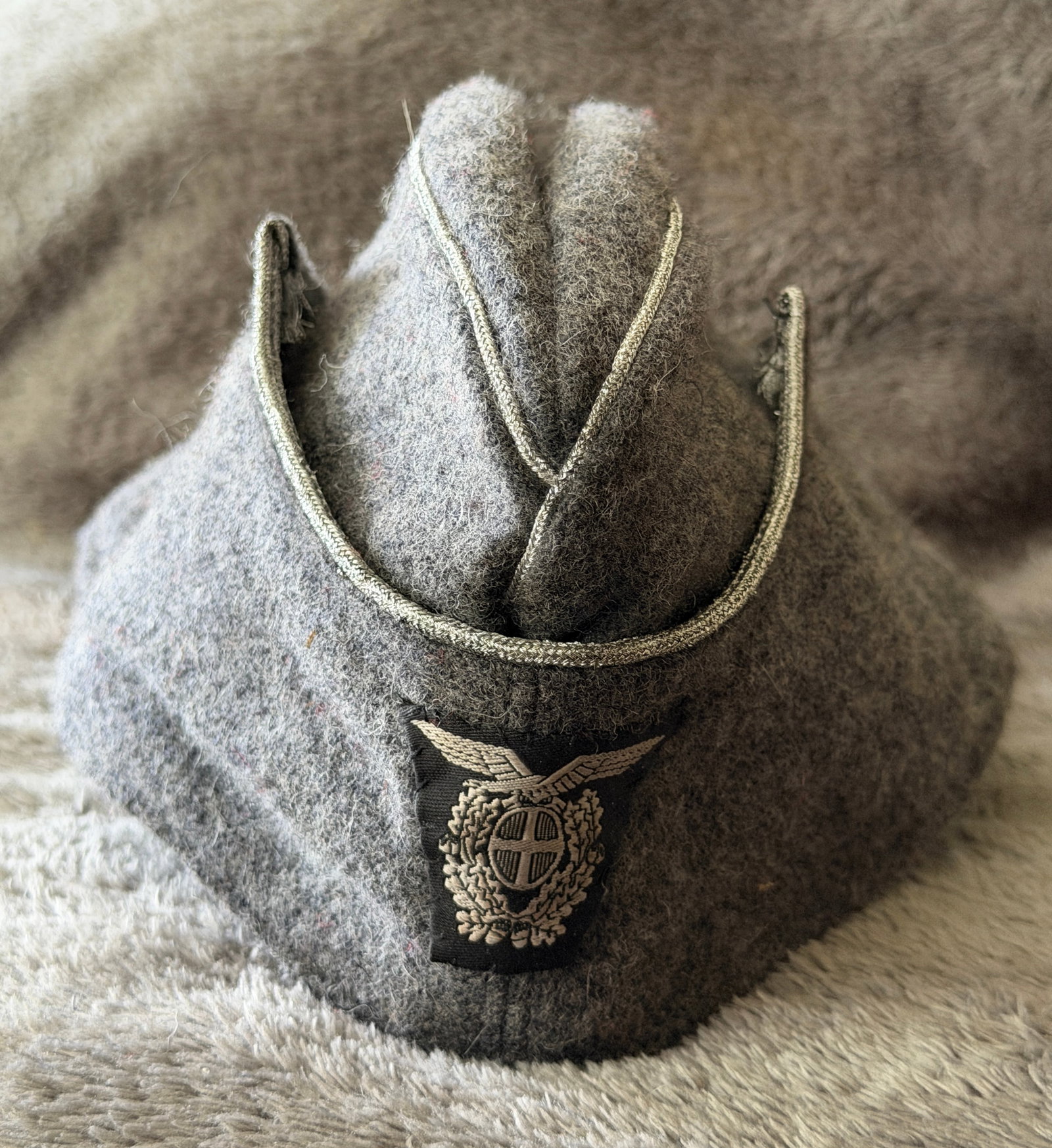 WWII Italian Regio Esercito M41 Feldmütze (Overseas Cap): This WWII Italian Regio Esercito M41 Feldmütze (overseas cap) is constructed of field-gray wool and features the distinctive fold-down crown characteristic of the Model 1941 design. The front is fitt