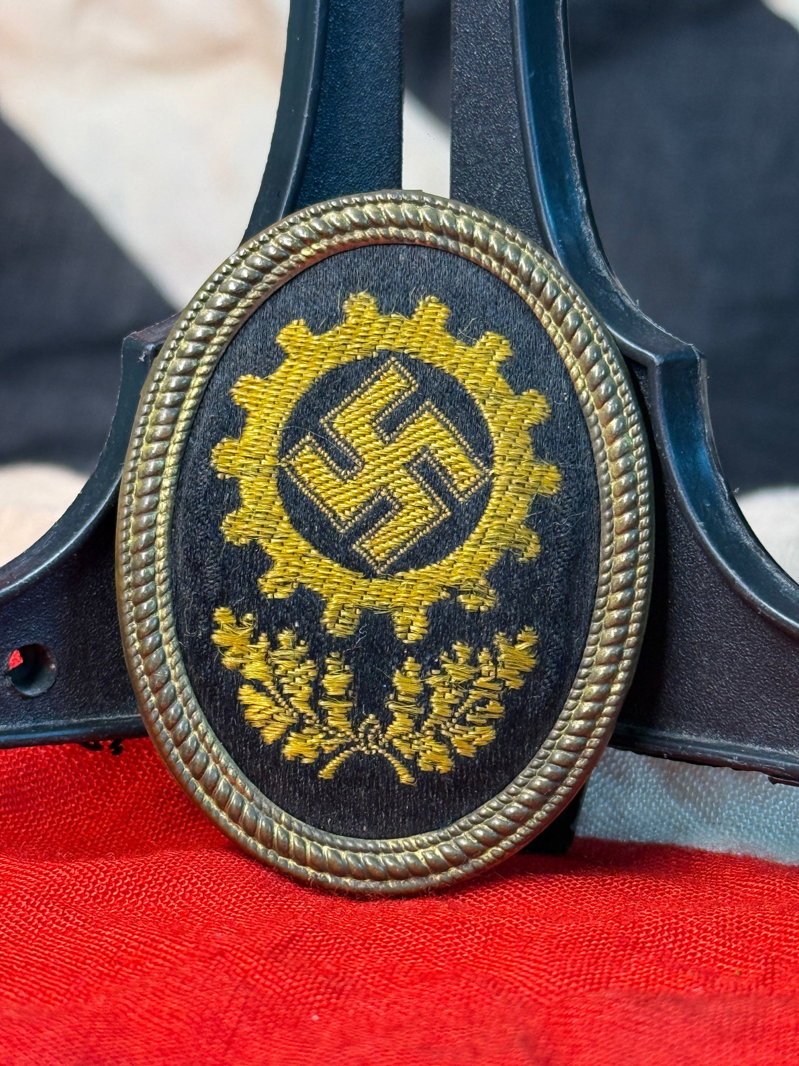 WWII German DAF Deutsche Arbeitsfront Embroidered Membership Badge – RZM Lieferant No. 357: This German organizational badge features the distinctive DAF (Deutsche Arbeitsfront / German Labour Front) cogwheel and swastika emblem embroidered in gold-colored thread on a black fabric field, wit