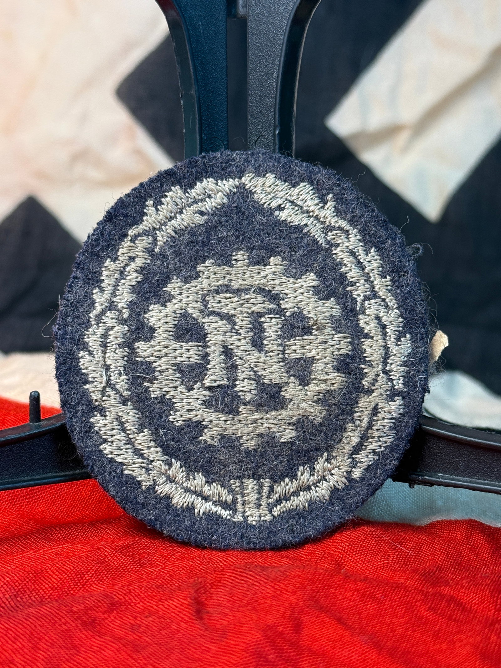 WWII German RAD Reich Labour Service Embroidered Sleeve Patch – RZM Hersteller Label: This German organizational insignia features the distinctive RAD (Reichsarbeitsdienst / Reich Labour Service) emblem embroidered in silver-gray thread on a dark wool backing. The central design depict