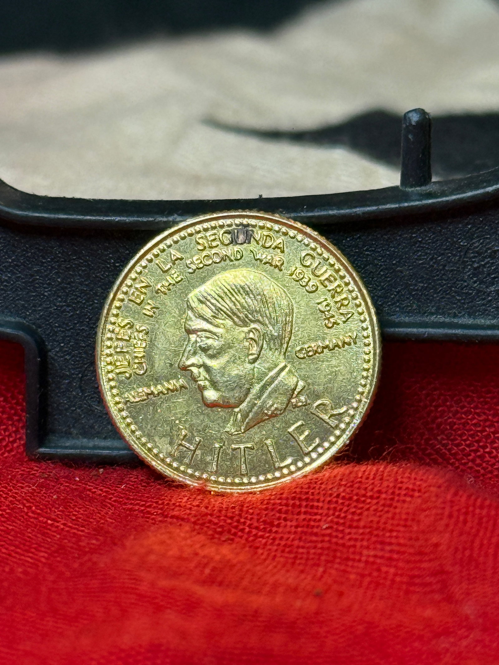 WWII German Adolf Hitler Commemorative Gold-Tone Medallion – “Eine Sekunda Guerra?? / Banco: WWII-era themed commemorative medallion featuring a left-facing portrait of Adolf Hitler surrounded by raised lettering and a beaded border. The obverse is prominently marked “HITLER” beneath 