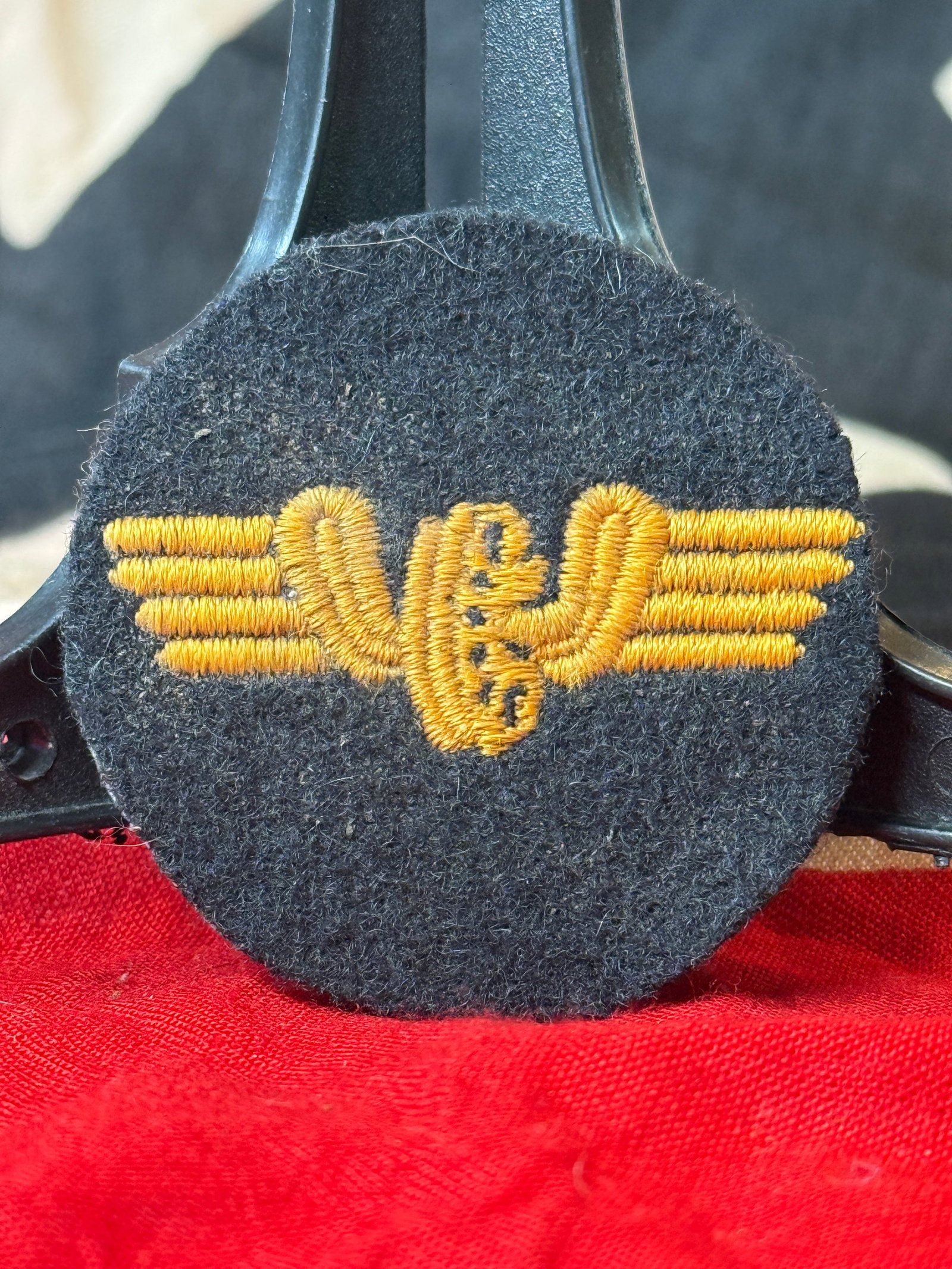 WWII German Army Medical Trade Sleeve Insignia: This WWII German Army medical trade sleeve insignia features a golden embroidered Rod of Asclepius flanked by stylized wings on a dark wool circular backing. Worn by medical personnel of the German Ar