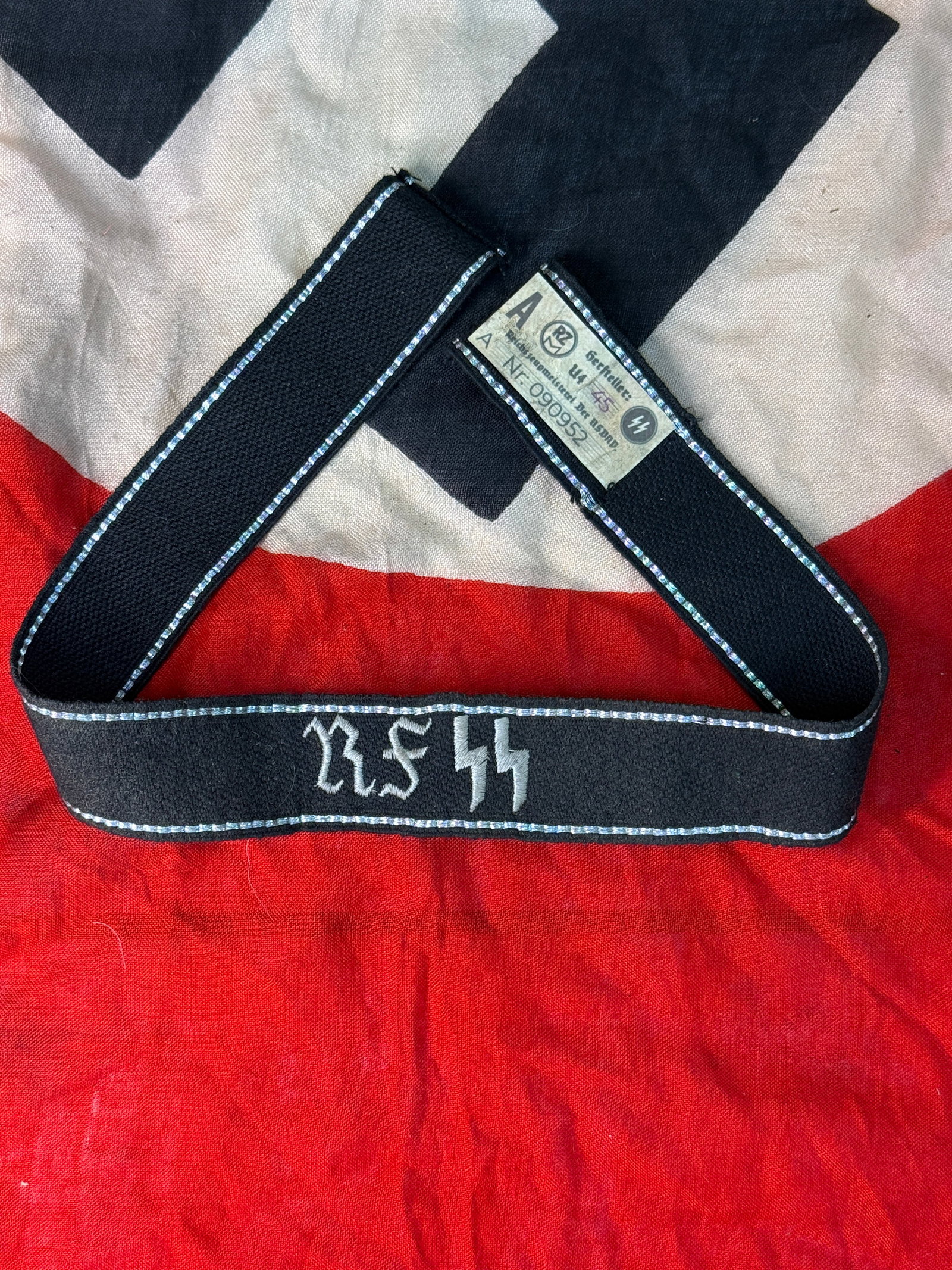 WWII German Waffen-SS RZM Marked Cuff Title: This black woven Waffen-SS cuff title features machine-embroidered silver-gray lettering reading "R.SS" with matching edge borders and retains its original RZM manufacturer's tag sewn into the interio