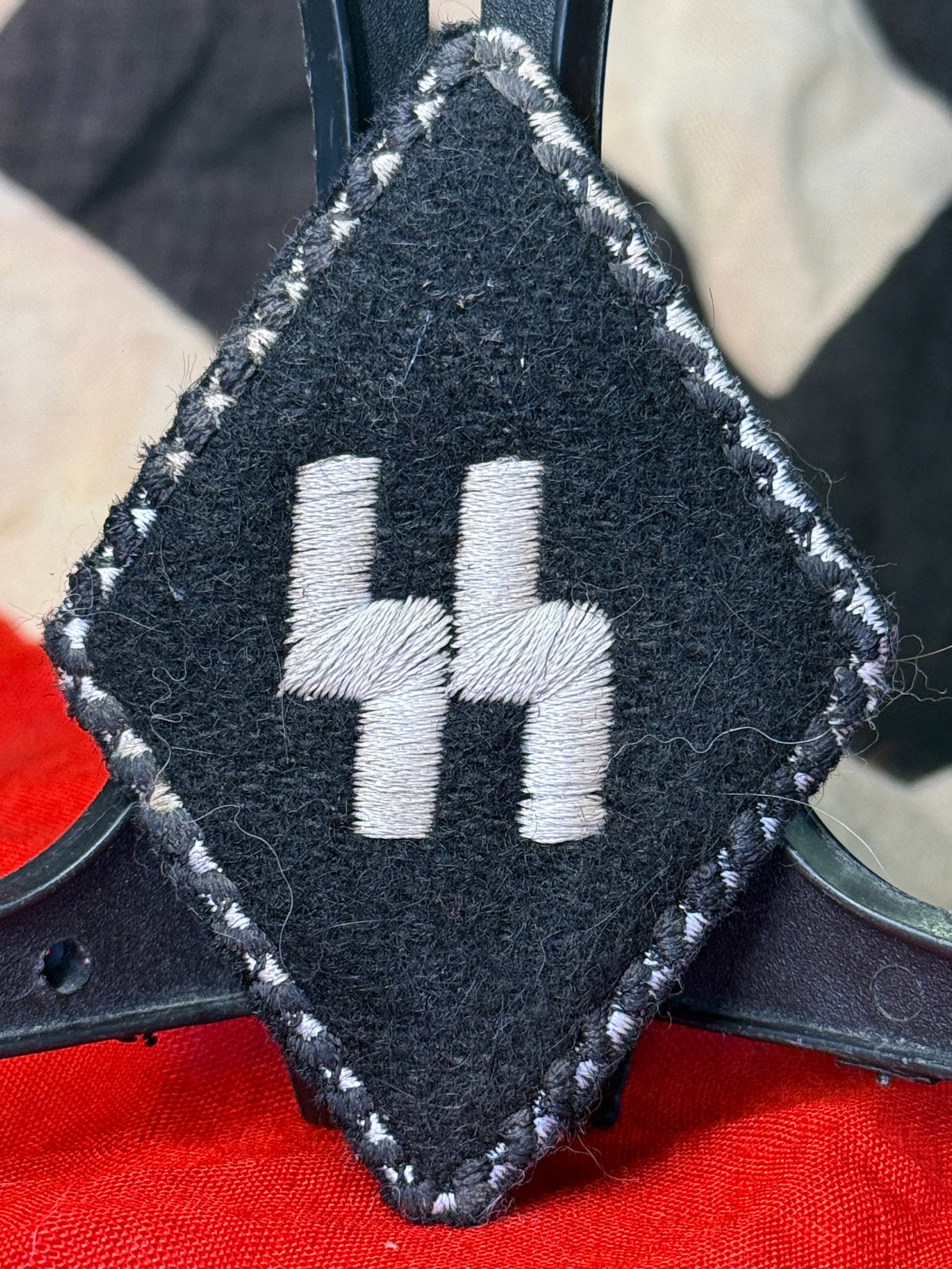 WWII German Waffen-SS Sleeve Diamond Insignia with RZM Tag: This black wool Waffen-SS sleeve diamond features embroidered white SS runes on its face and retains an original RZM inspection and production label affixed to the reverse. Sleeve diamonds of this typ