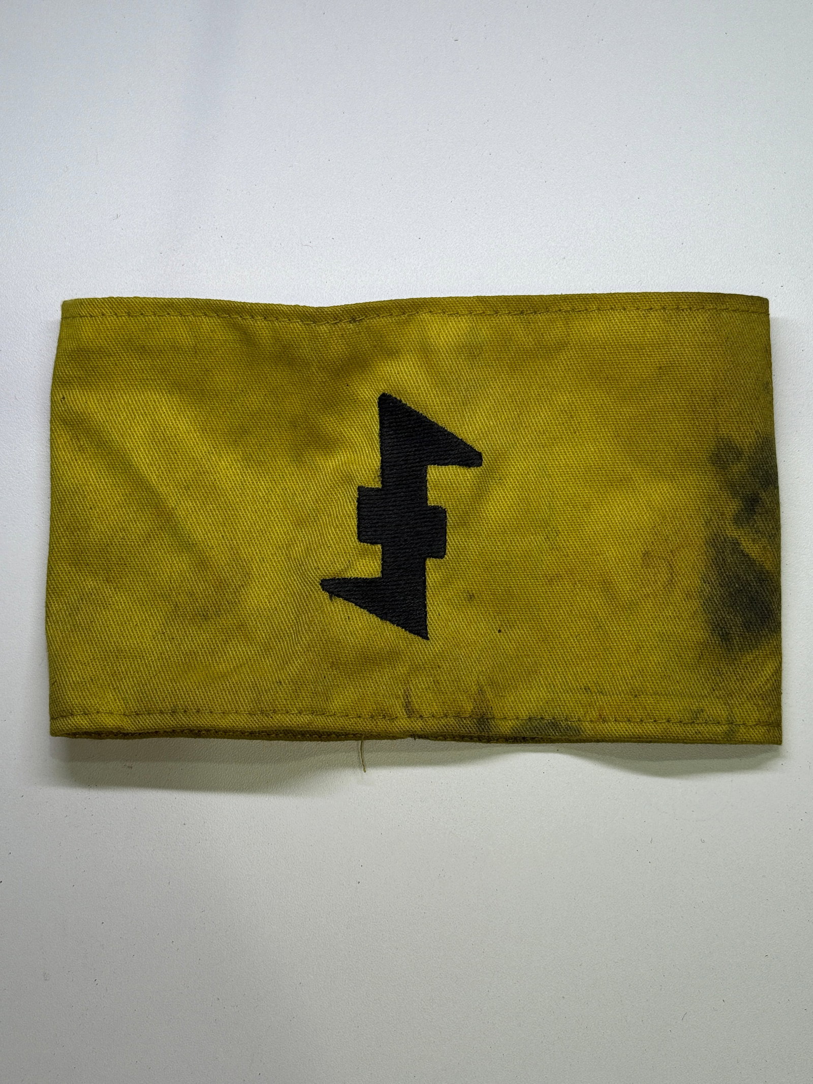 WWII Dutch National Socialist Movement (NSB) Yellow Wolfsangel Armband: A yellow canvas identification armband associated with the Dutch Nationaal-Socialistische Beweging, or NSB, which collaborated with German occupation authorities during WWII. The front bears a machine