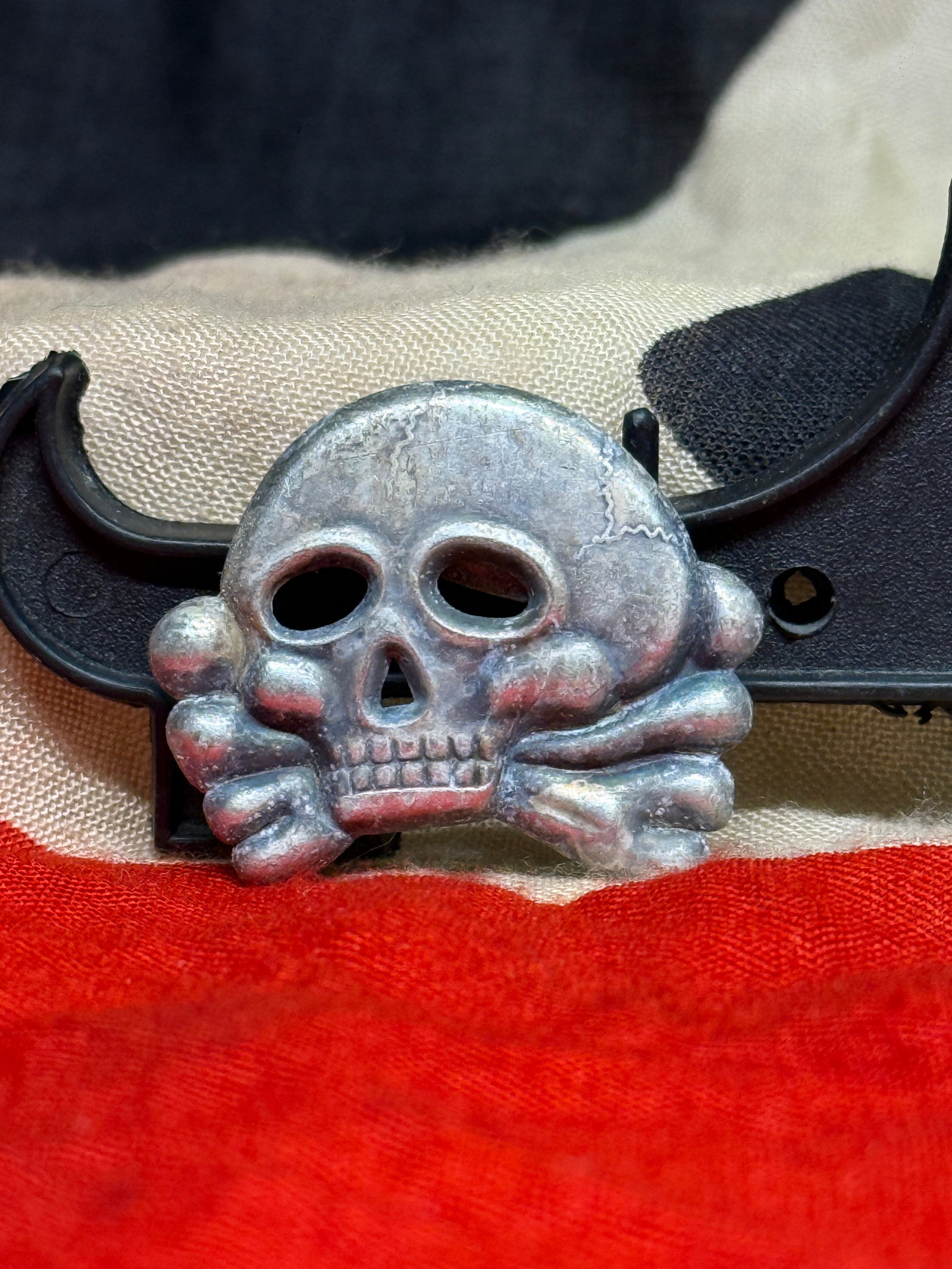 WWII German SS Totenkopf Skull & Crossbones Metal Cap Badge Insignia: This WWII German SS-style Totenkopf cap badge features the distinctive skull and crossbones design associated with SS headgear and related German military insignia. The metal badge is executed in a si