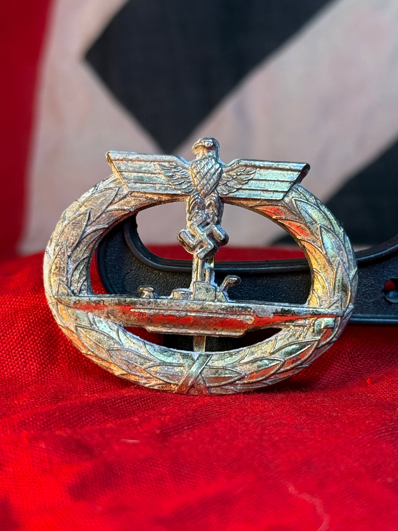 WWII German Kriegsmarine U-Boat War Badge by Schwerin, Berlin: A gilt-metal Kriegsmarine U-Boat War Badge depicting a submarine in side profile within an oval laurel wreath, surmounted by the German national eagle and swastika. Instituted in 1939, this decoration