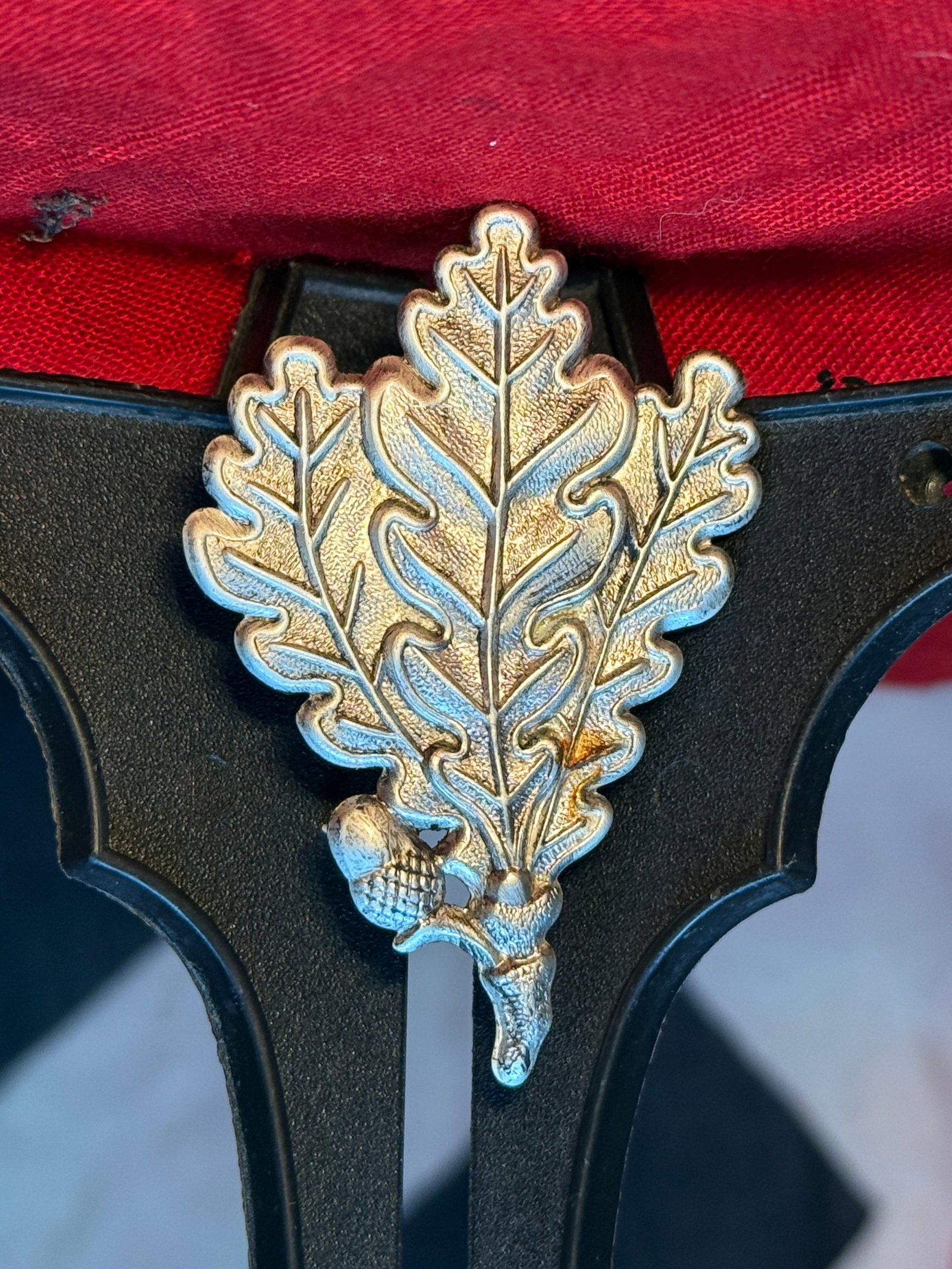 WWII German Army Jäger Oak-Leaf Cap Insignia: A silver-colored metal cap insignia formed as a cluster of three overlapping oak leaves with an acorn at the upper edge. This traditional oak-leaf device was associated with German Army Jäger light-i