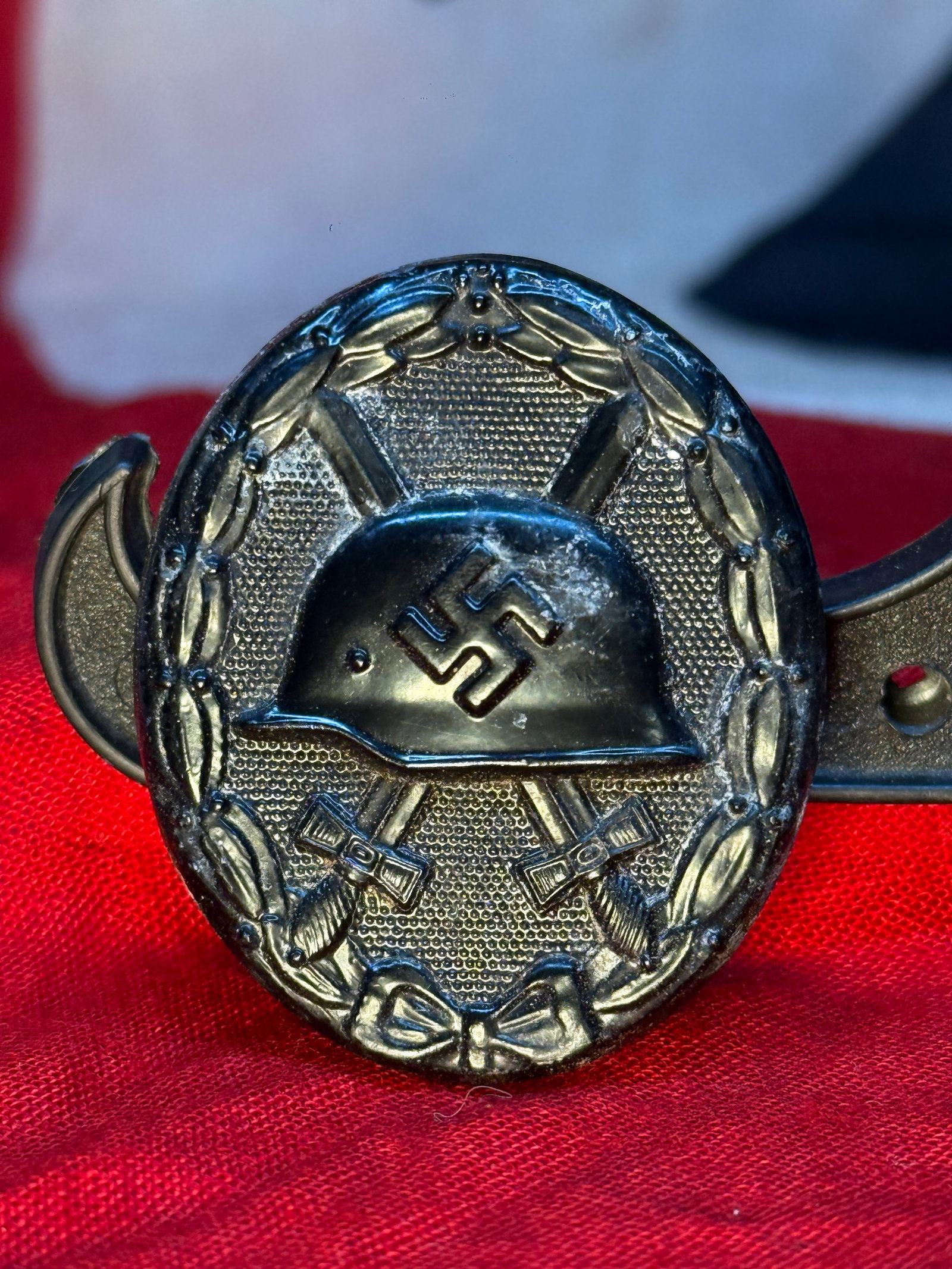 WWII German Black Wound Badge, Maker Code 30—Hauptmünzamt Wien: A 1939-pattern German Black Wound Badge displaying an M35-style steel helmet bearing a swastika above crossed swords, surrounded by an oval laurel wreath tied with a bow at the bottom. The black grade